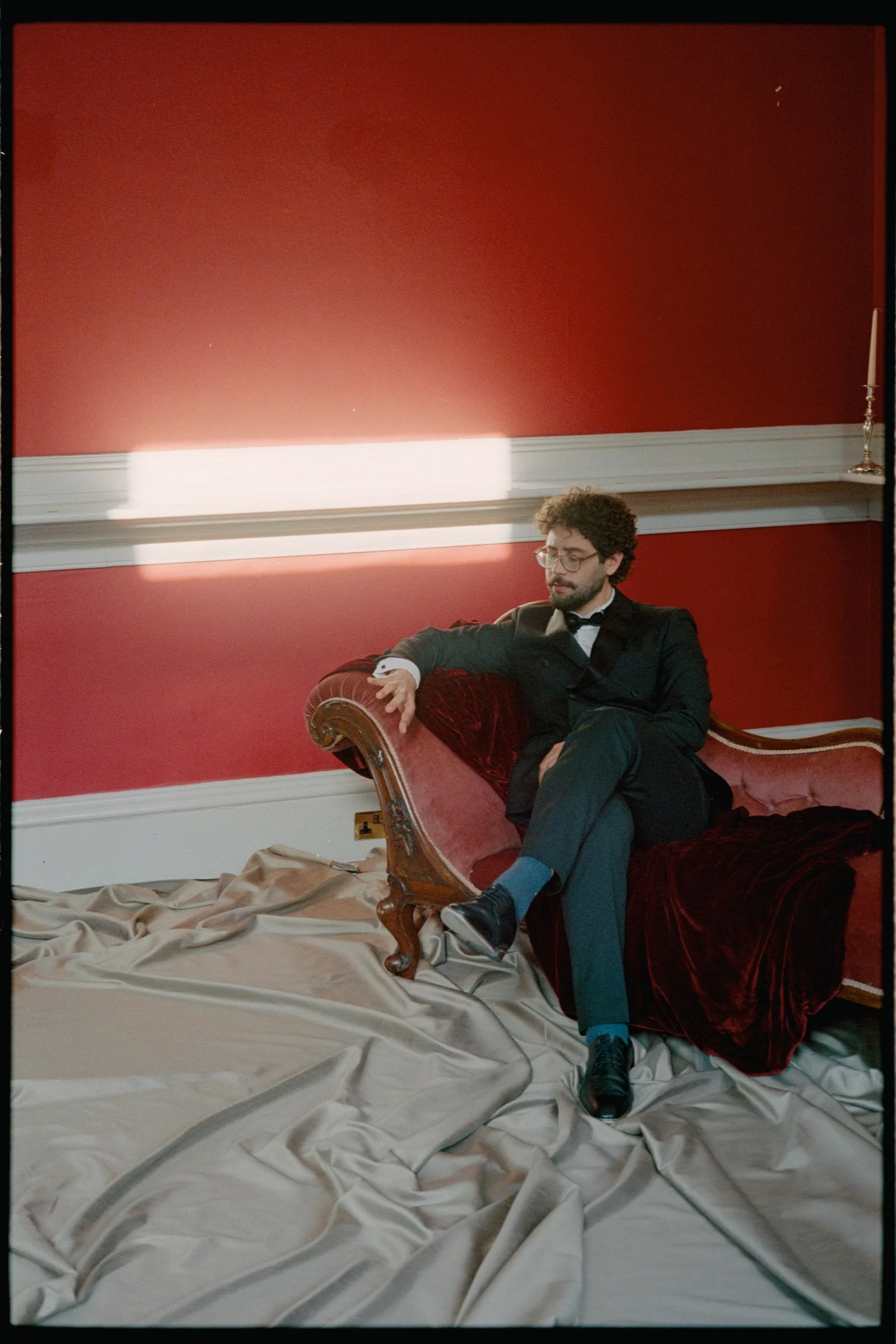 Male stage performer seated in a red chair during the conceptual shoot