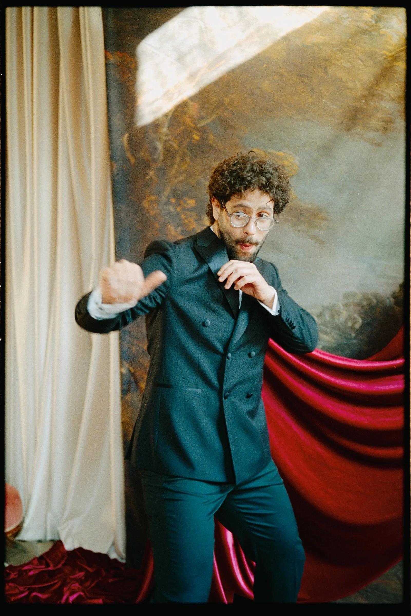 Male performer adjusting his collar in the theatre set on colour film