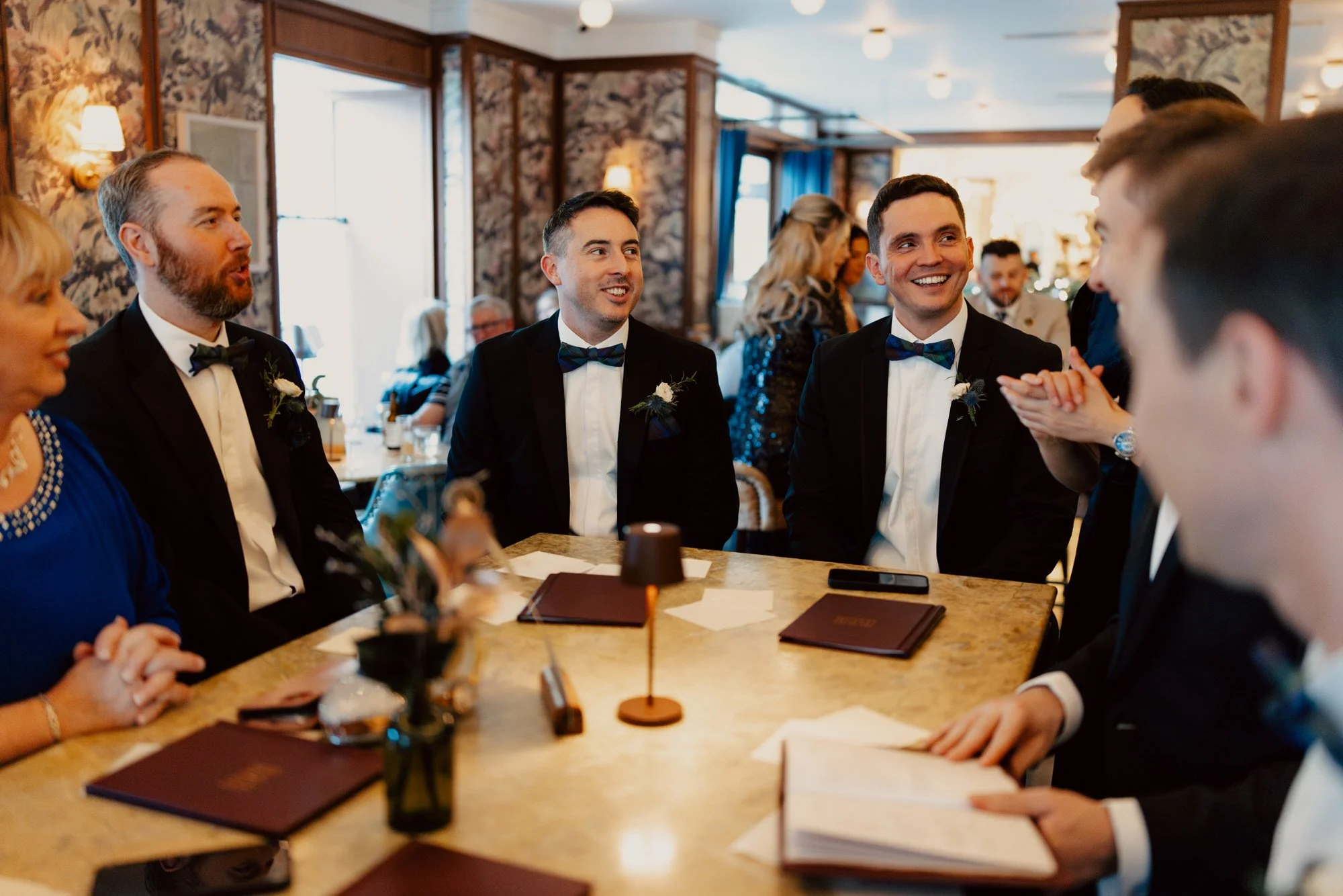 Vincent and the boys sharing drinks around a table in the hotel bar.