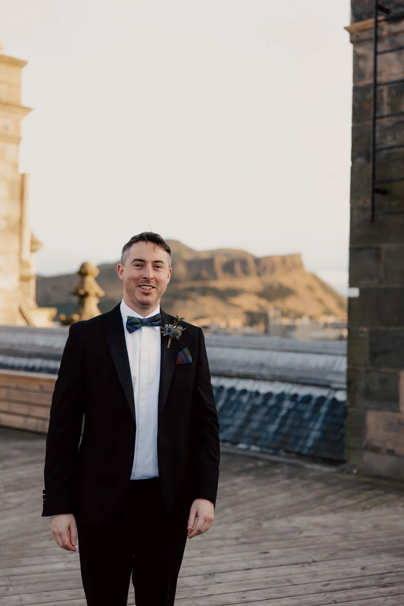 Vincent standing on the hotel rooftop in his black tuxedo.