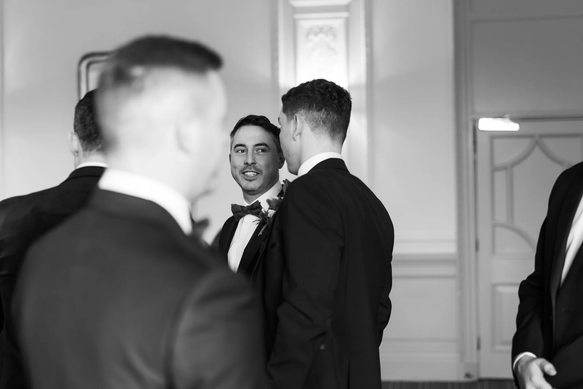 Black-and-white photograph of Vincent chatting with the men before the ceremony.