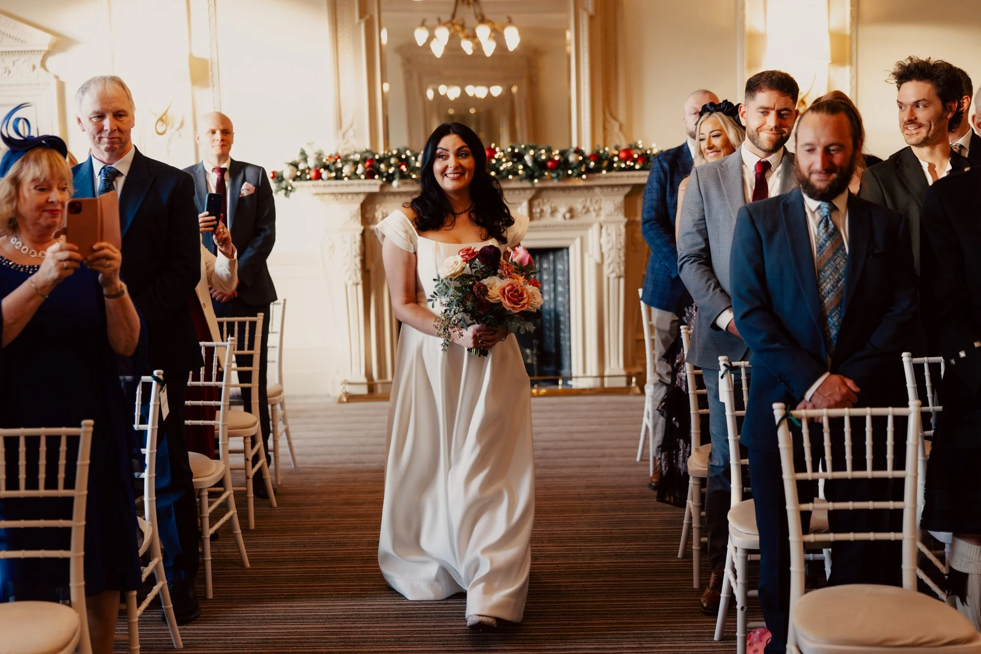 Milly walking down the aisle carrying her bouquet.