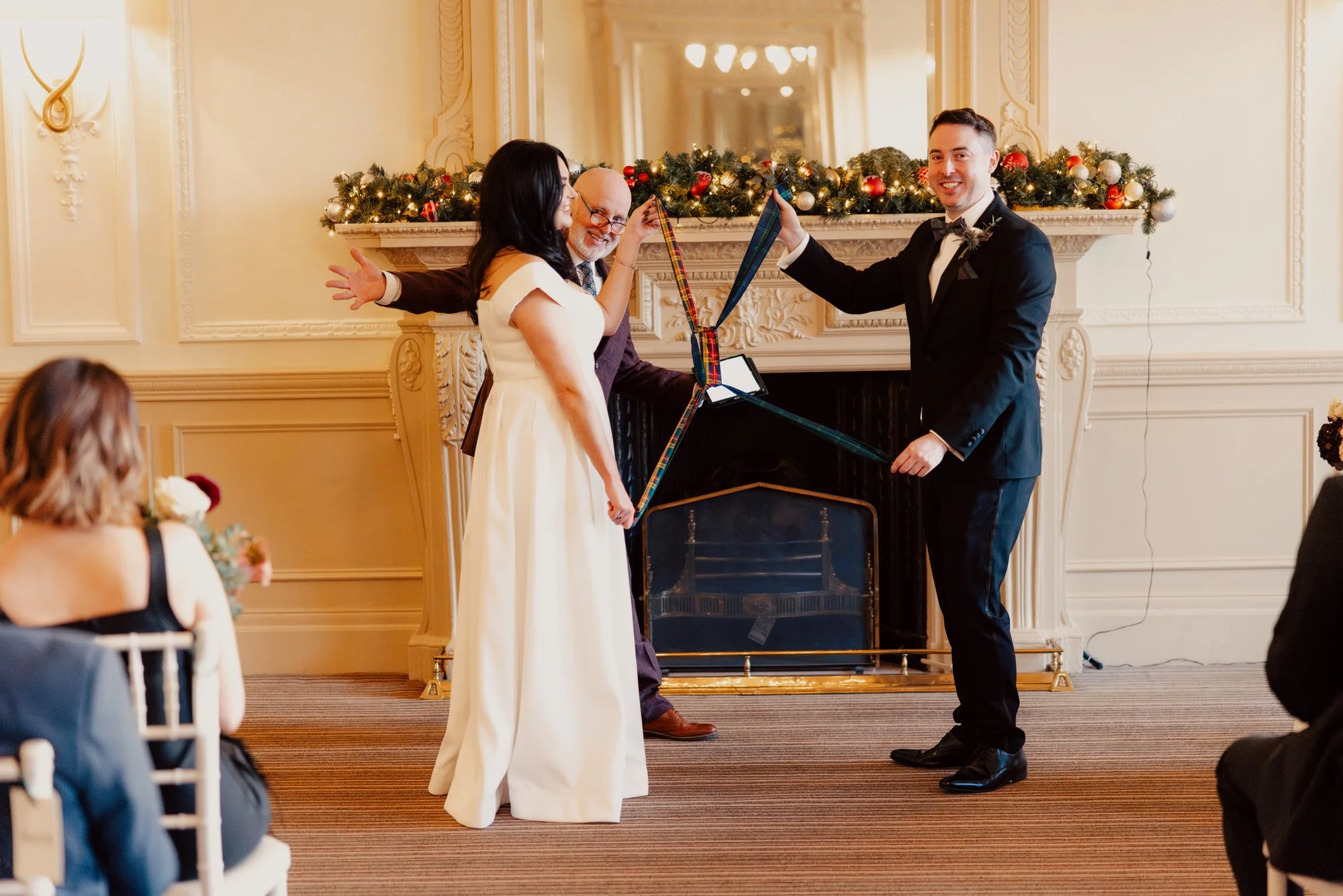 Milly and Vincent holding ribbons during their wedding ceremony.
