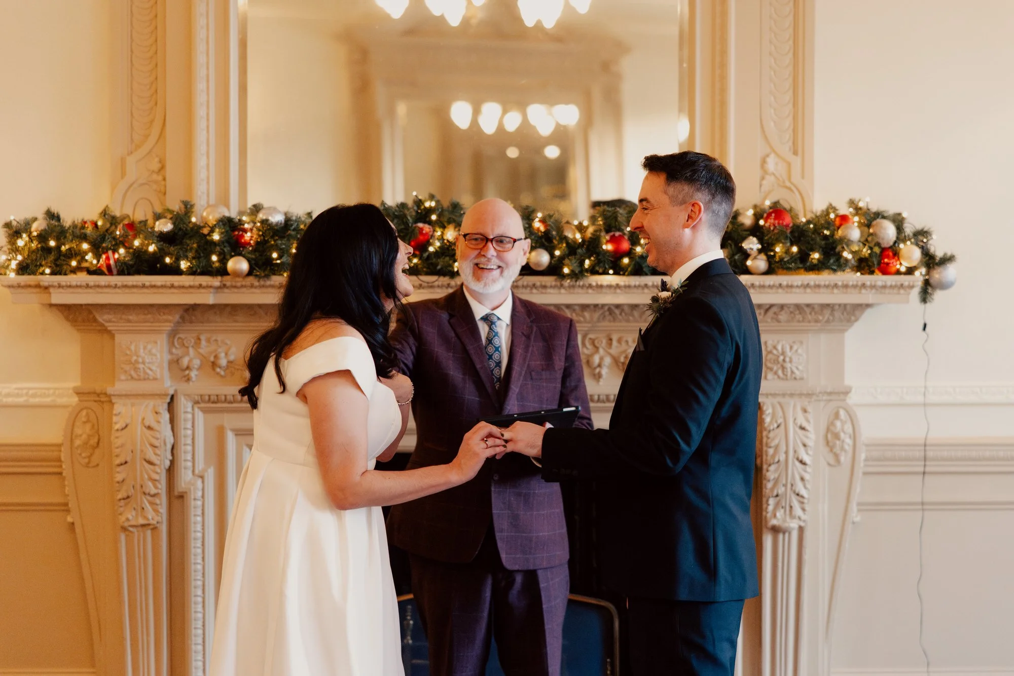 The couple holding hands as Alan Ness leads their ceremony.