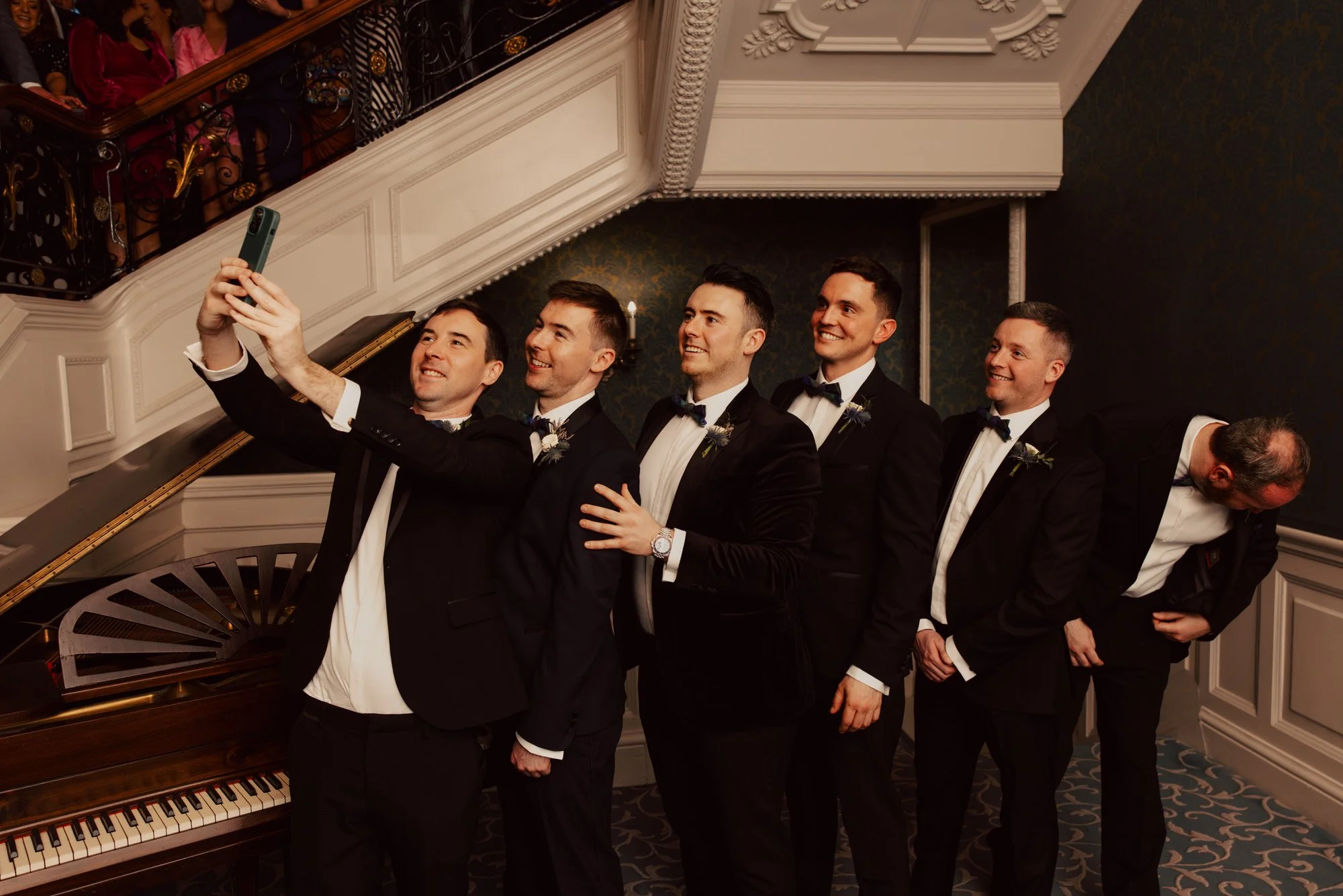 Vincent and the groomsmen taking a selfie on the hotel staircase.