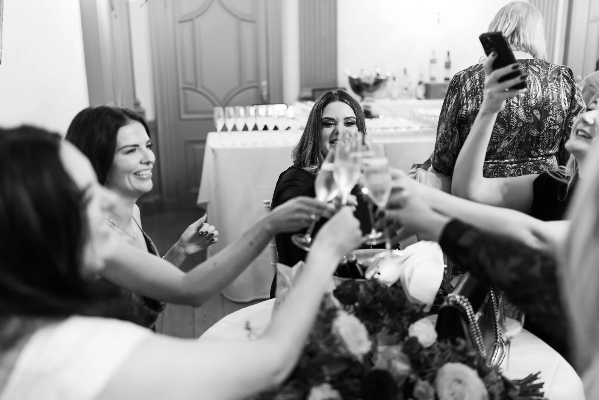 Friends raising glasses around Milly during the reception.
