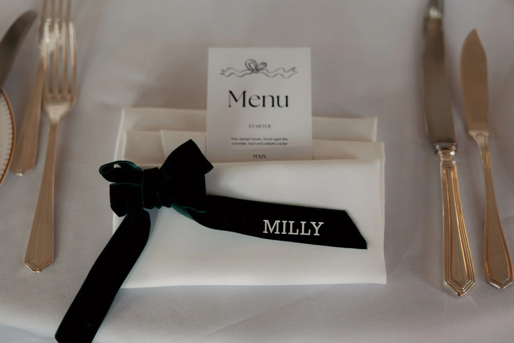 Milly’s place setting with a menu and black ribbon.