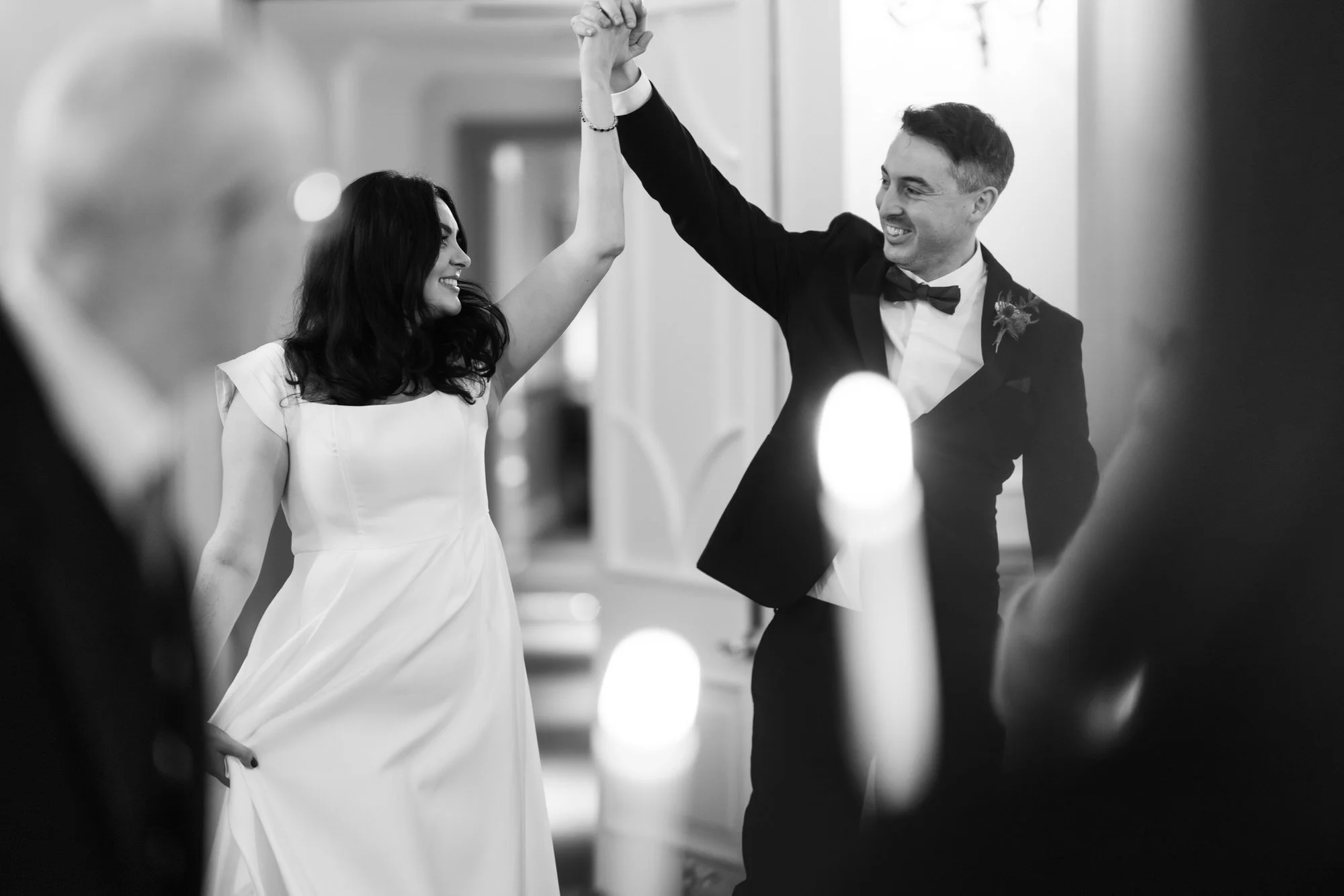 The couple entering their wedding breakfast with hands raised.