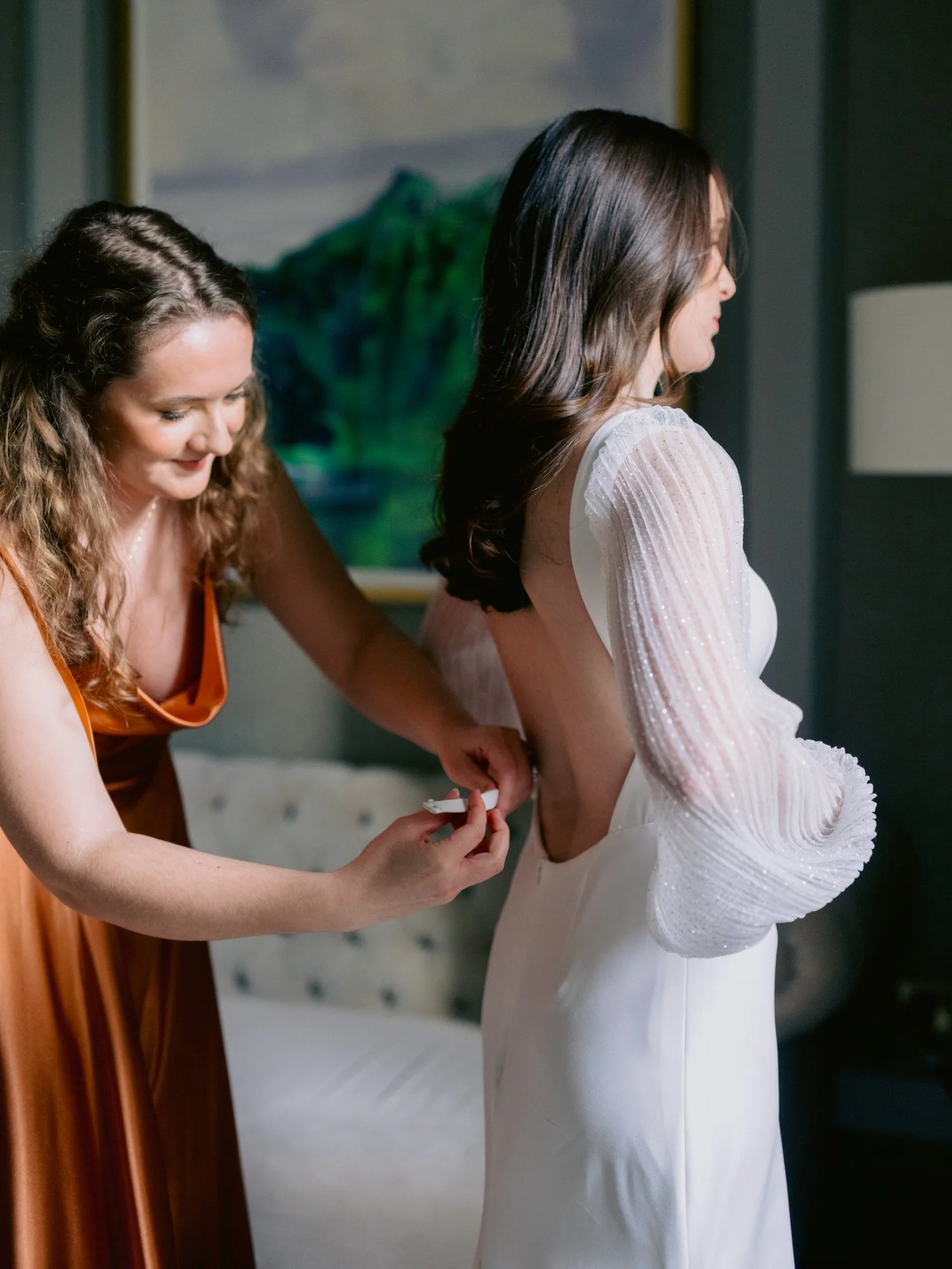 Bridesmaid helping Nicola fasten her wedding dress