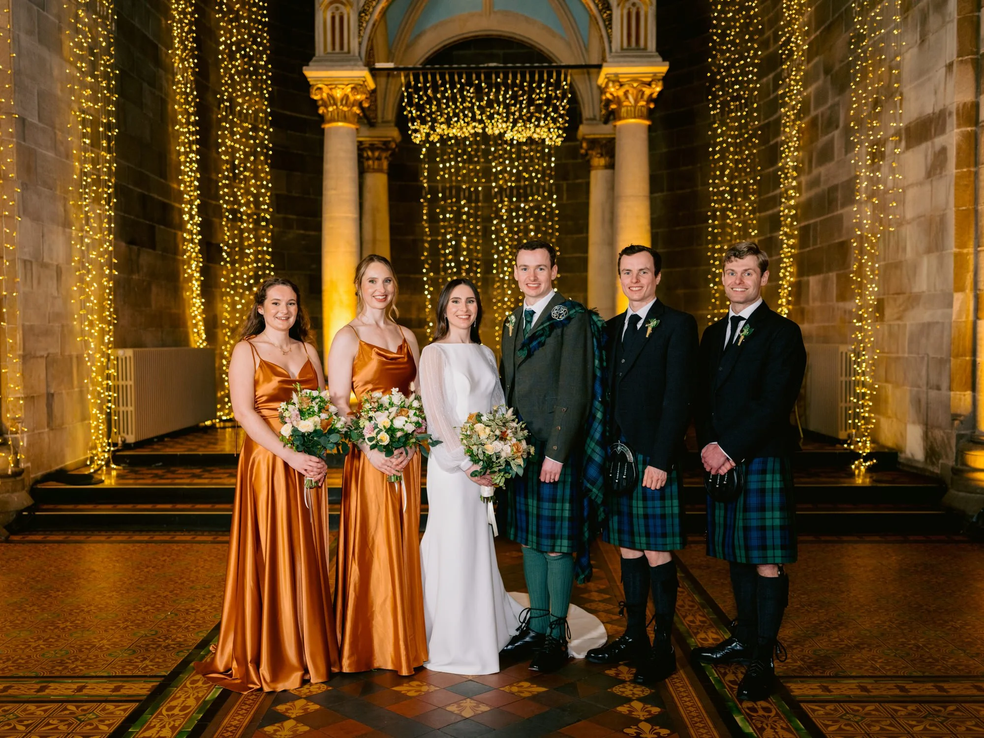 Wedding party posing beneath the lights at Mansfield Traquair