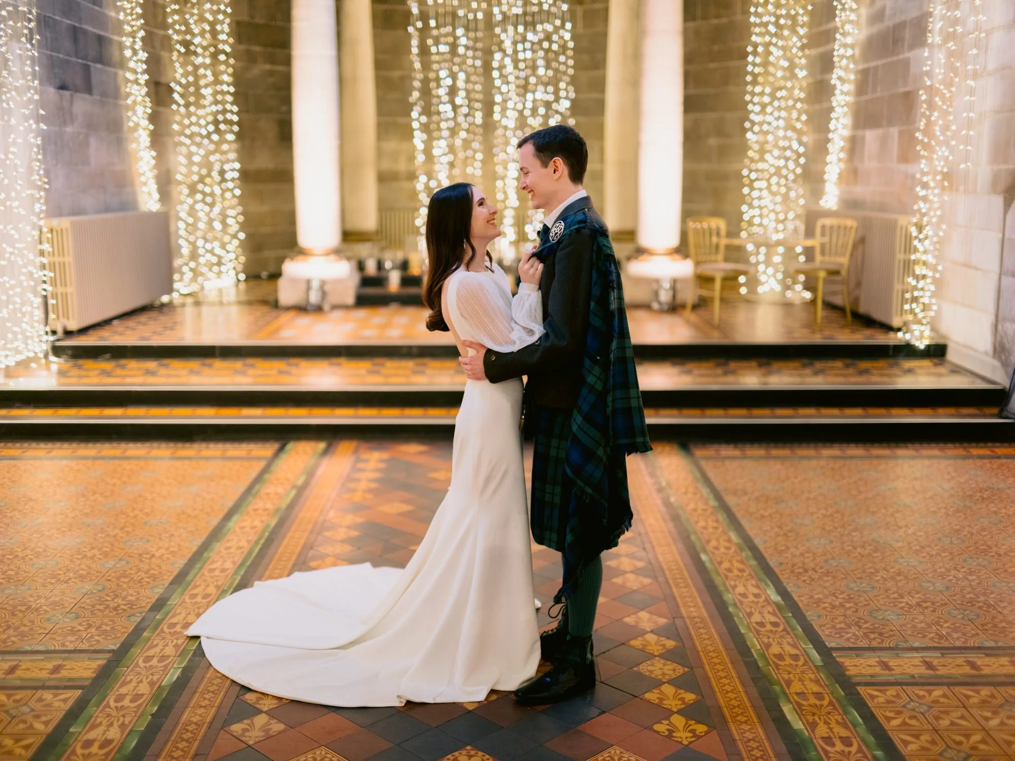 Nicola and Fraser embracing on the tiled floor inside the venue