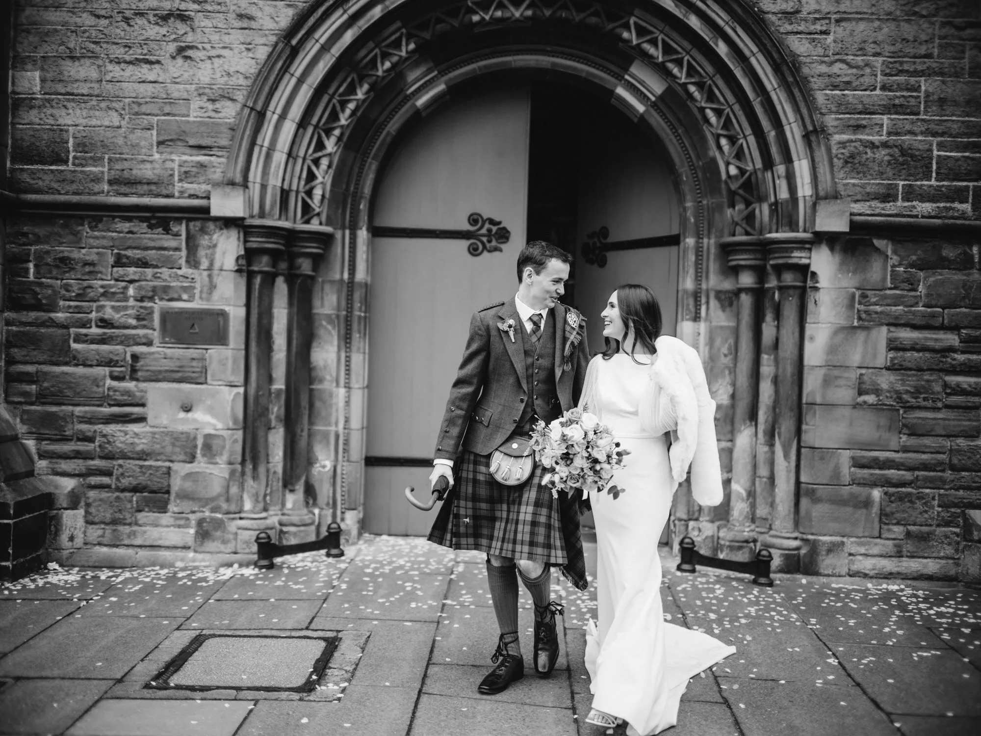Black-and-white portrait of the couple at the stone entrance