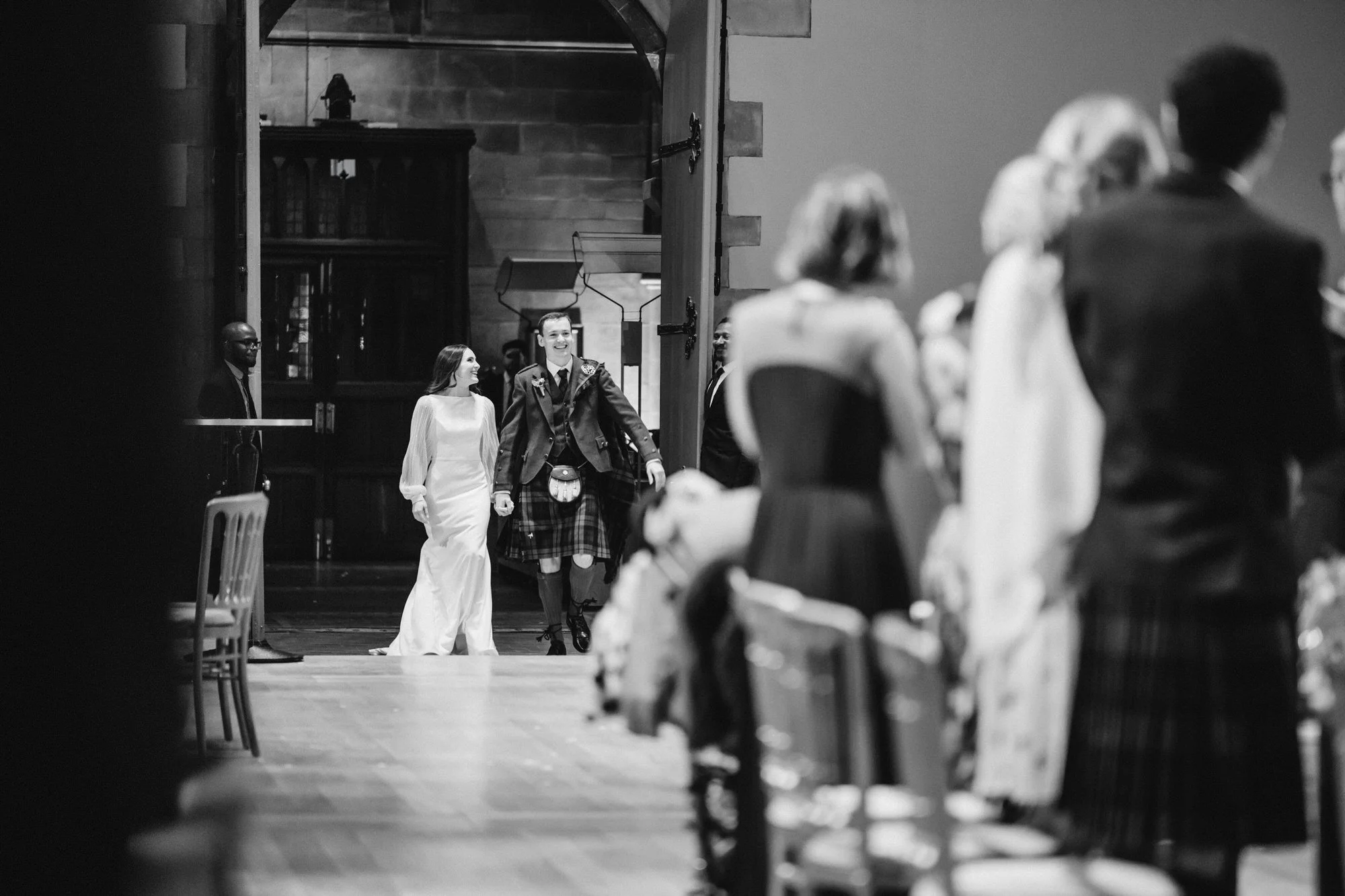 Black-and-white photograph of the couple entering the wedding reception