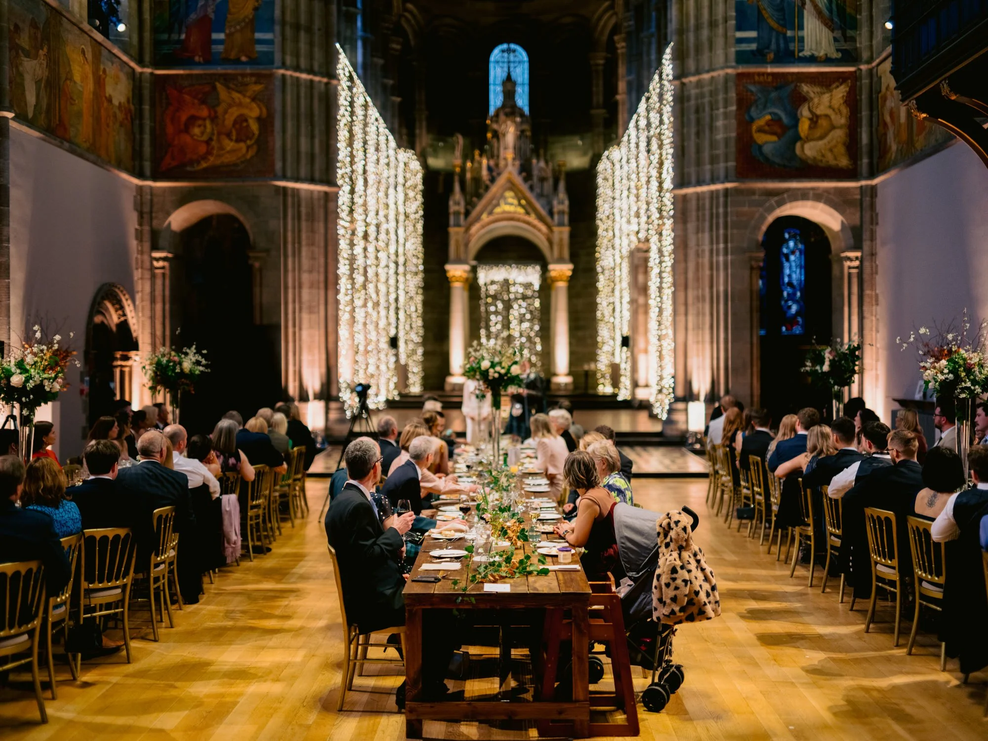 Guests seated at long tables beneath the Mansfield Traquair murals