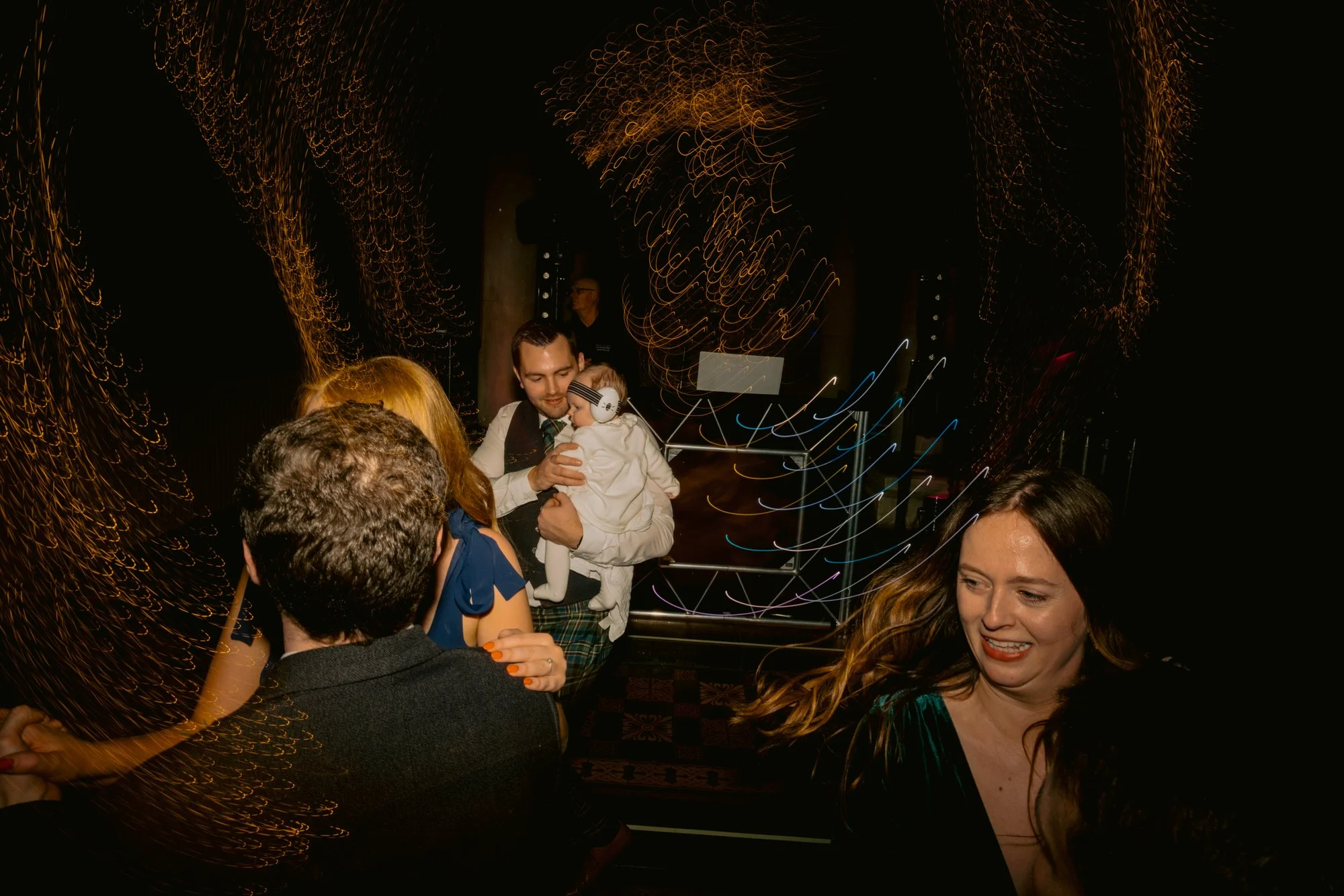 Wedding guests dancing together in the darkened venue