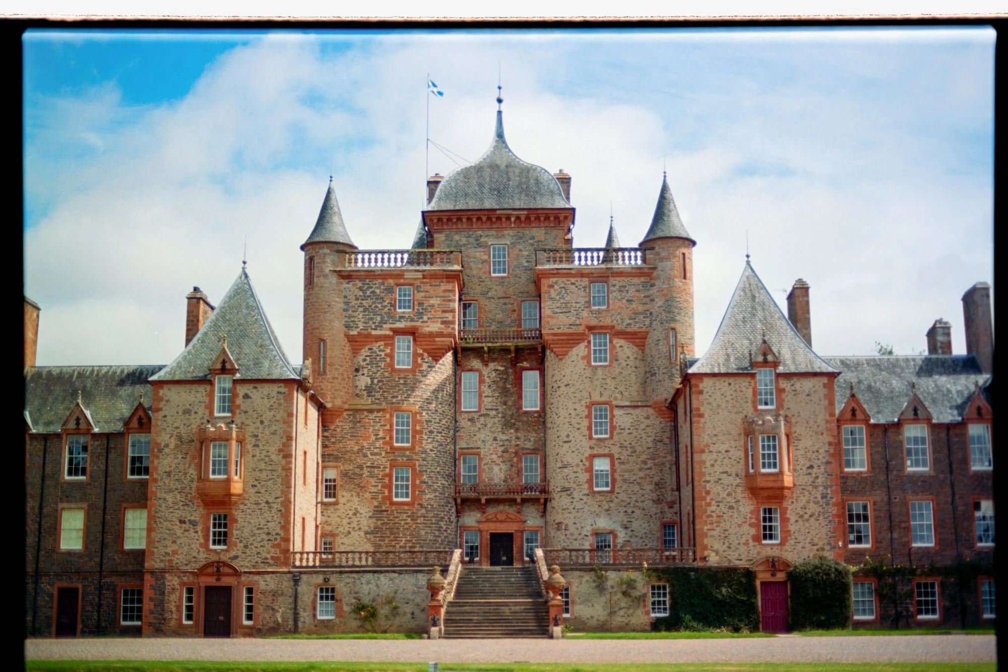 Thirlestane Castle's turrets and front steps beneath a blue sky in Lauder.