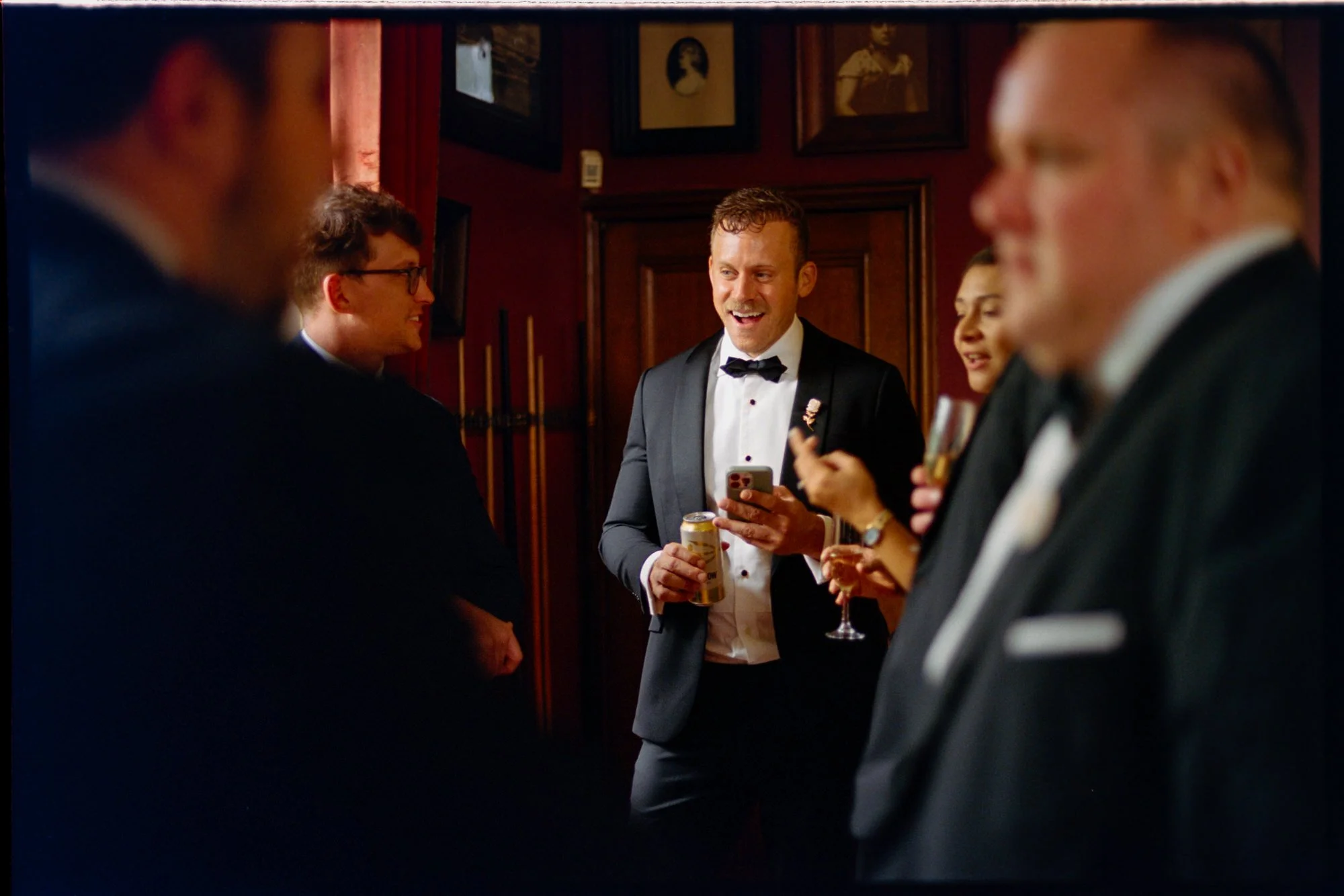 A groom laughing with friends over drinks before the ceremony.
