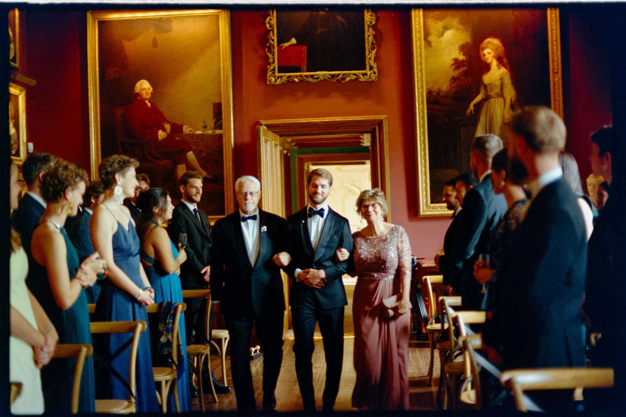 The grooms walking together between rows of wedding guests.