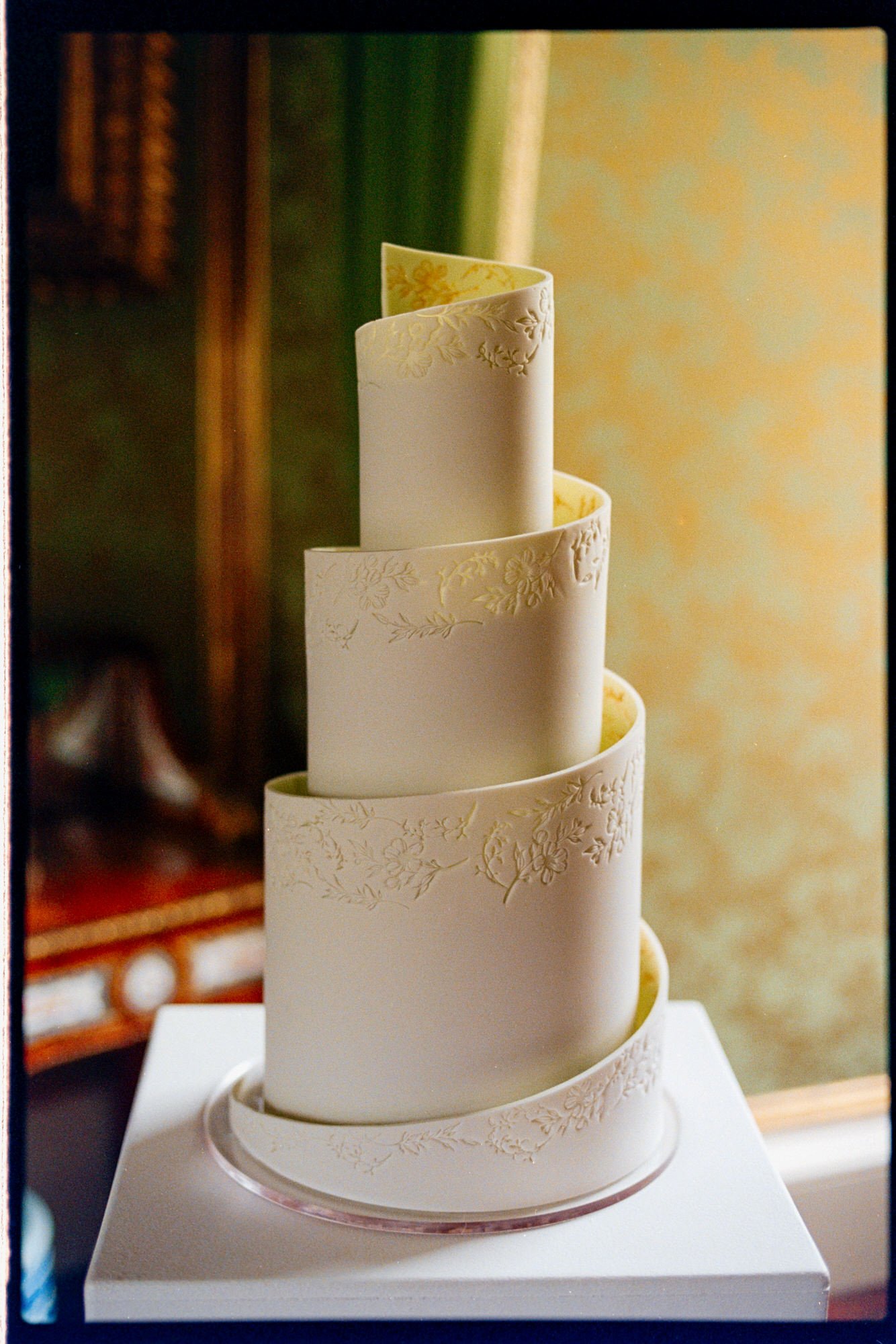 Close-up of the curved tiers and textured finish of the wedding cake.