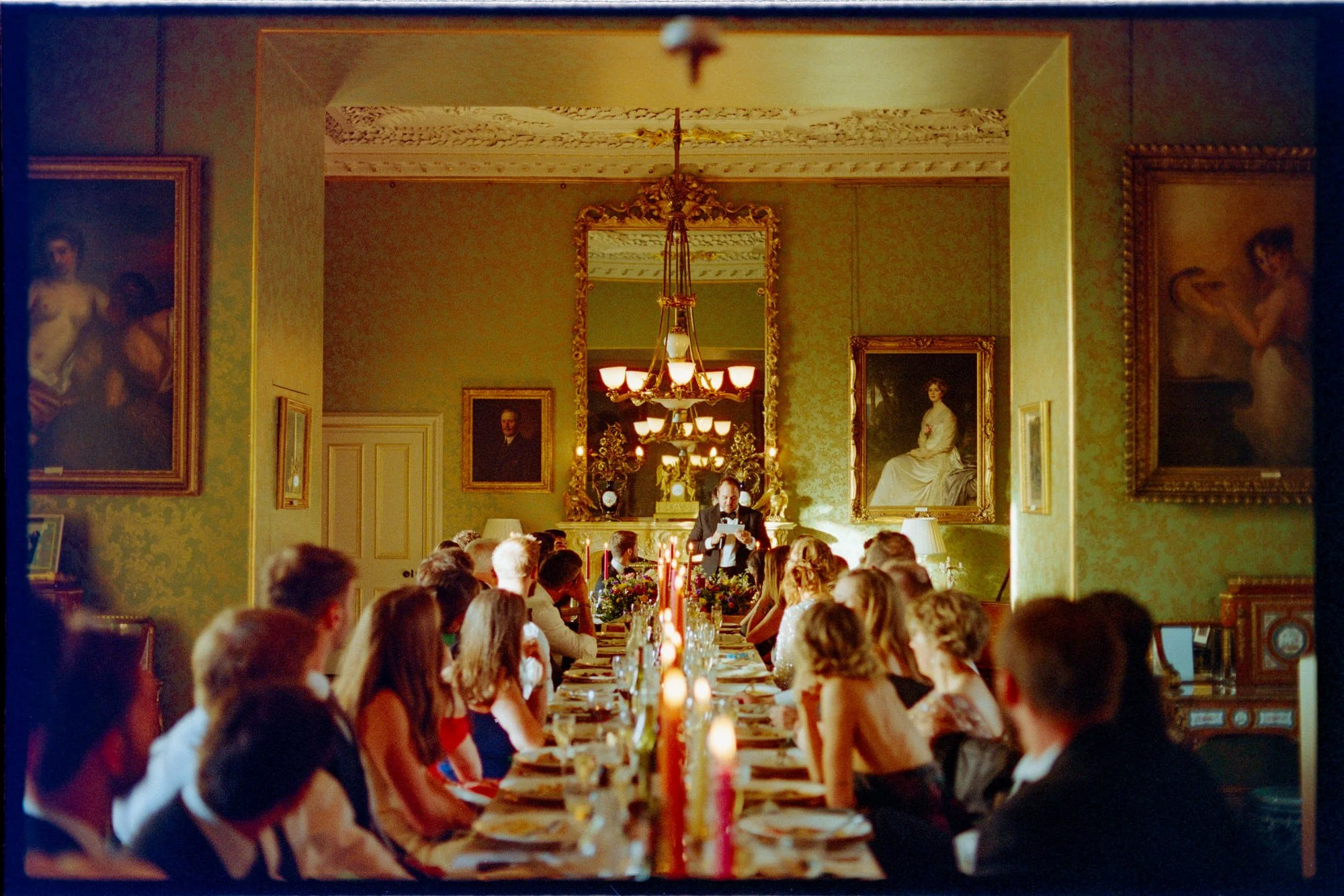Wedding guests seated around a candlelit table at Thirlestane Castle.