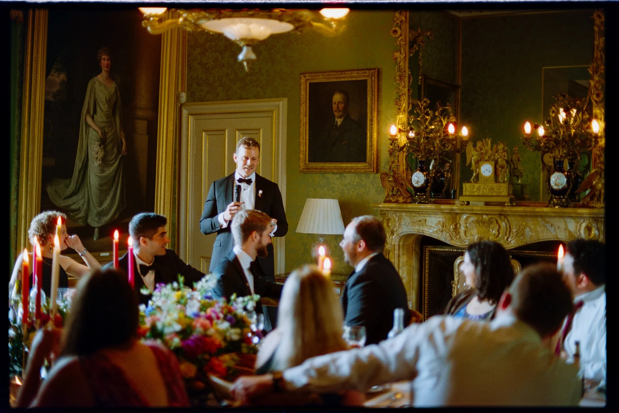 A guest giving a speech beside the long wedding dinner table.