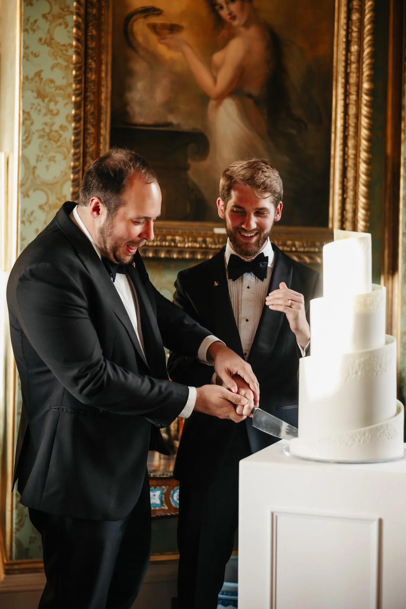 The newlyweds cutting their tiered wedding cake together.