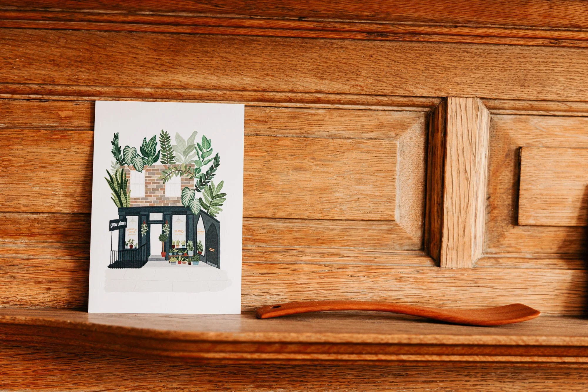 An illustrated wedding card resting against a wooden door