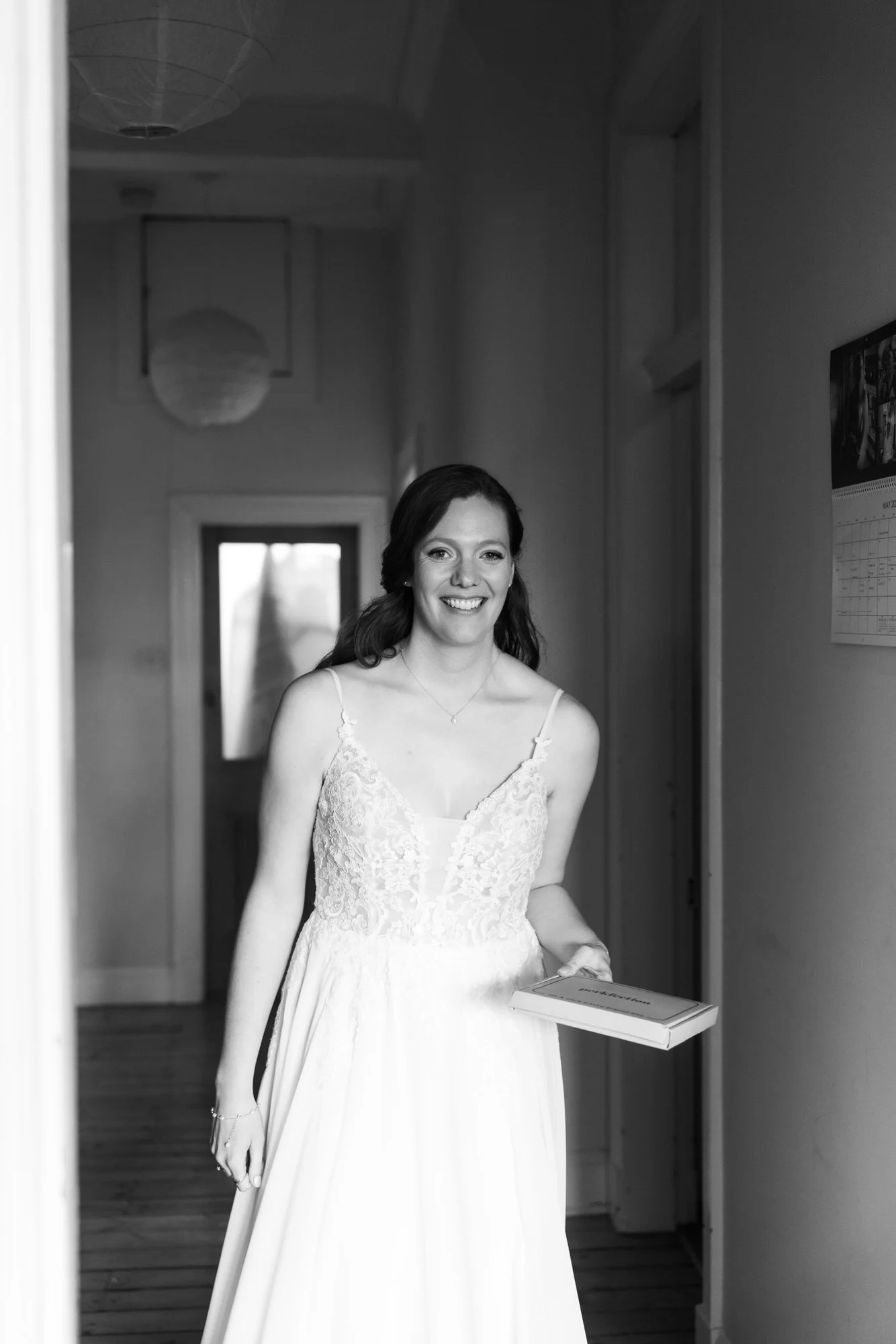 A bride standing in an Edinburgh flat doorway in black and white