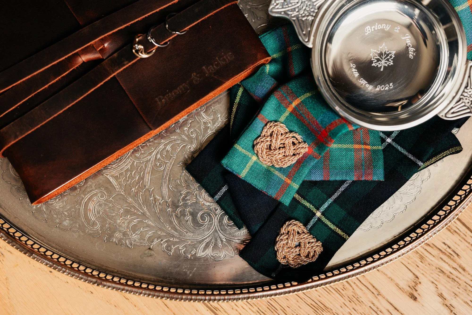 An engraved quaich with tartan and wedding stationery