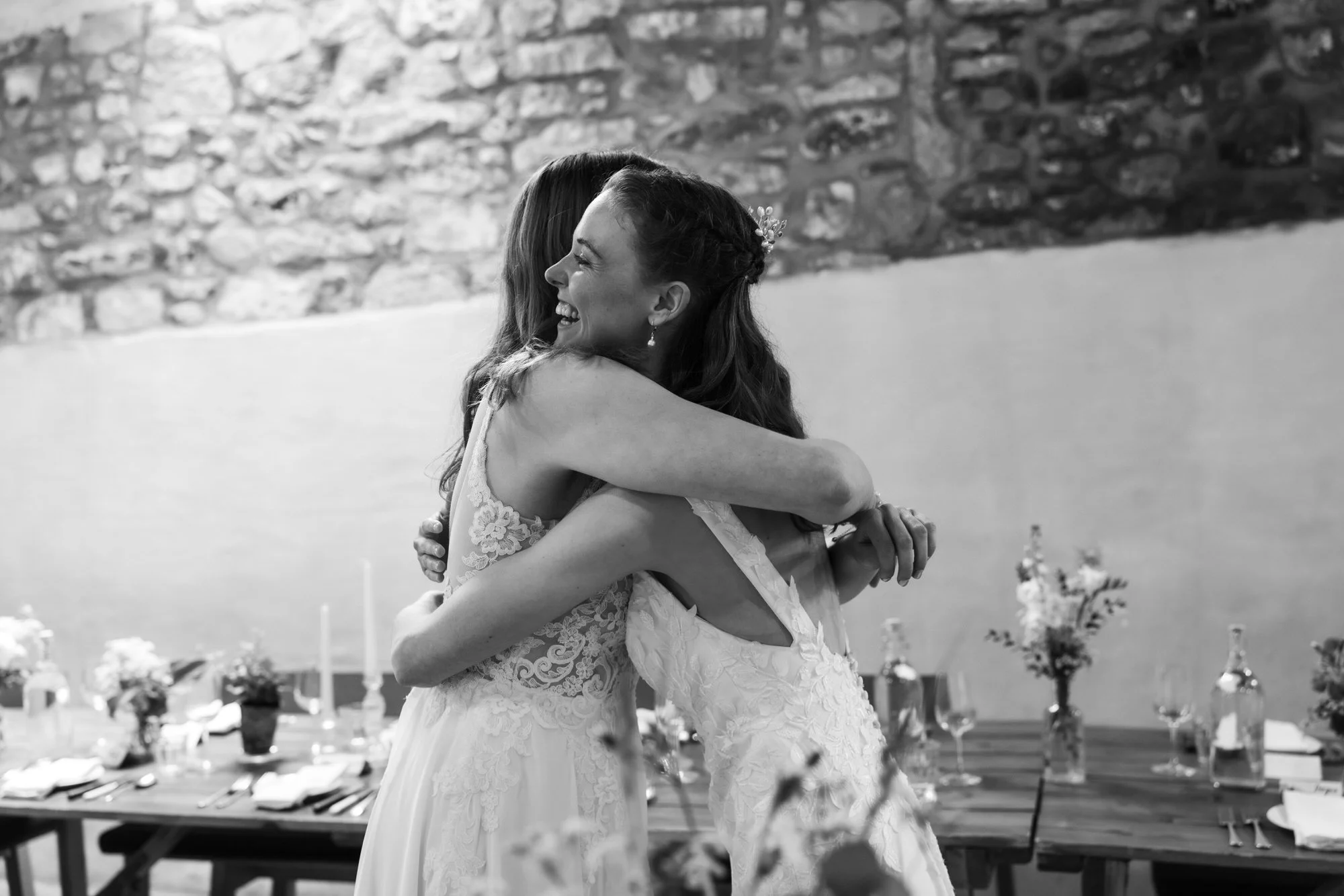 Jackie and Briony embracing at their first look in black and white