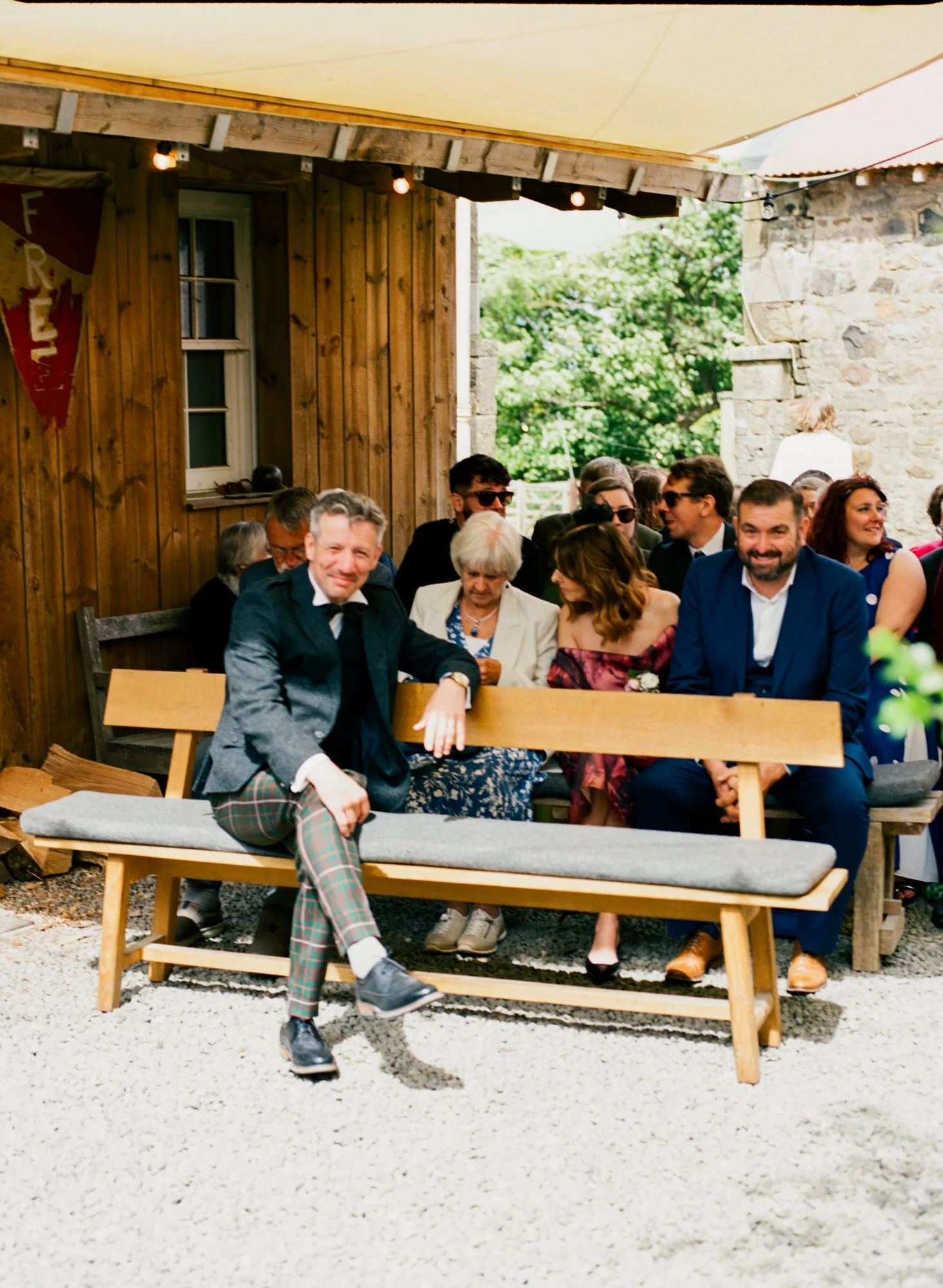 The wedding party sitting together on a courtyard bench