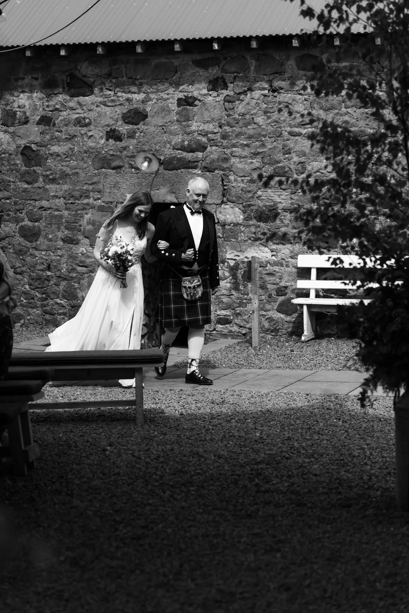 A guest wearing a kilt in the stone courtyard