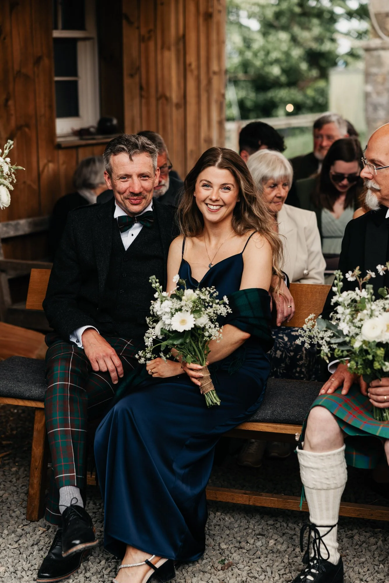 Wedding guests seated closely on wooden benches