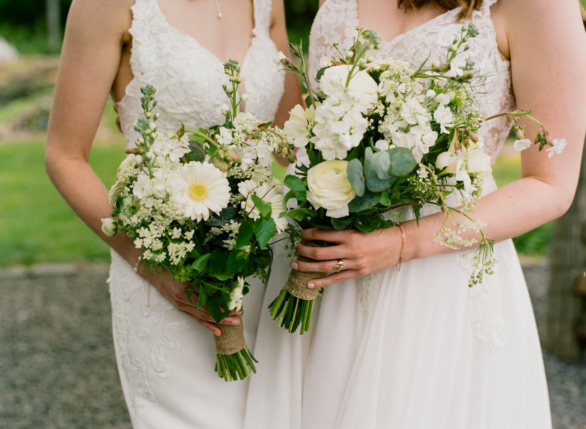 White and green bouquets held by Jackie and Briony