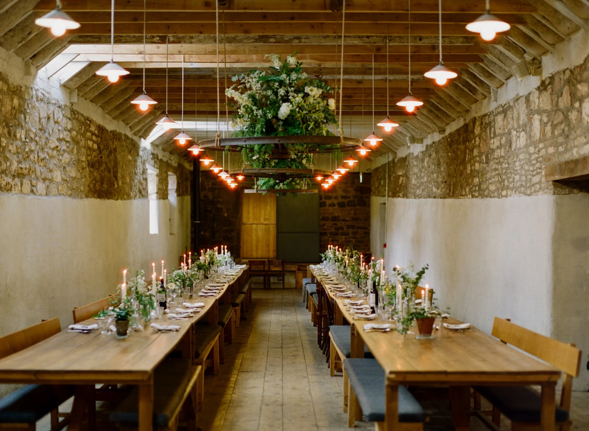 Long wooden dinner tables set for the wedding meal