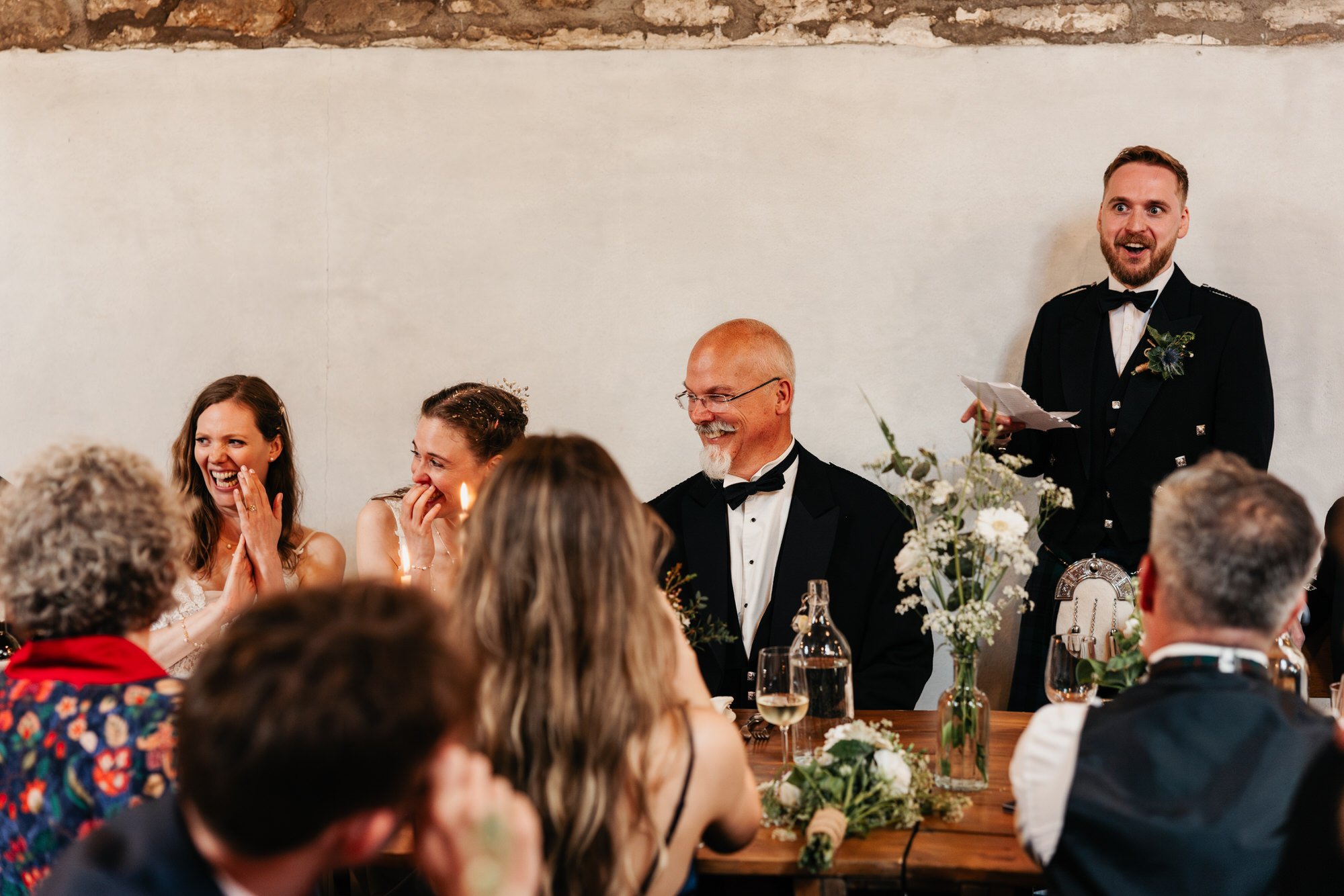Guests laughing during a wedding speech