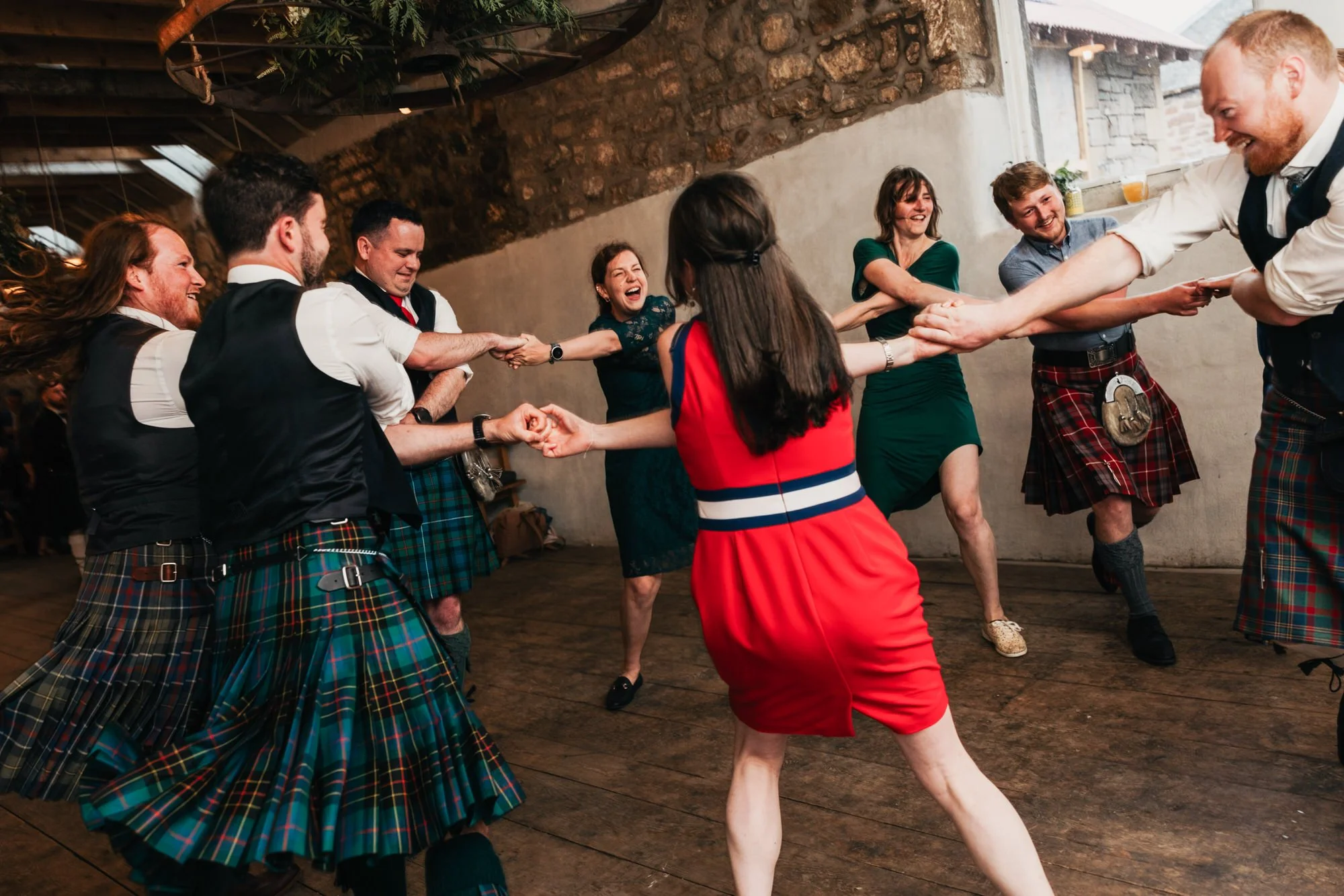 Wedding guests linking hands during the ceilidh
