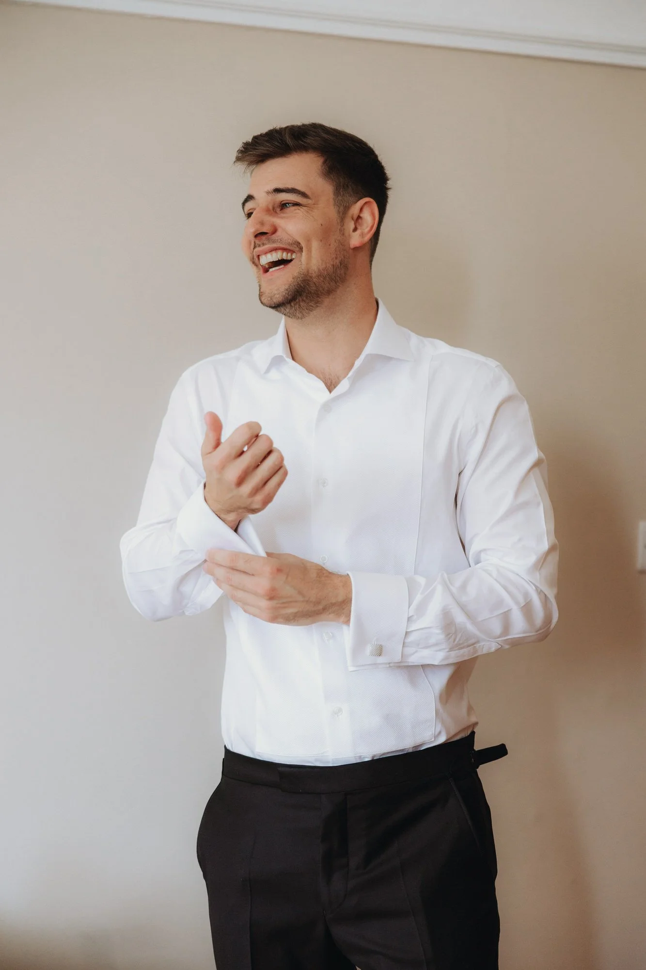 Jonathan fastening his shirt cuffs before the wedding