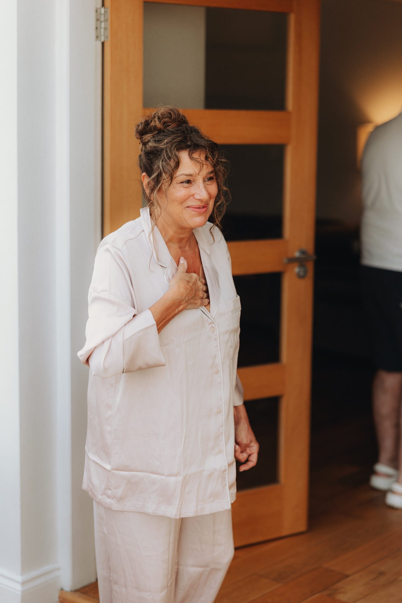 A wedding guest holding a drink in the doorway
