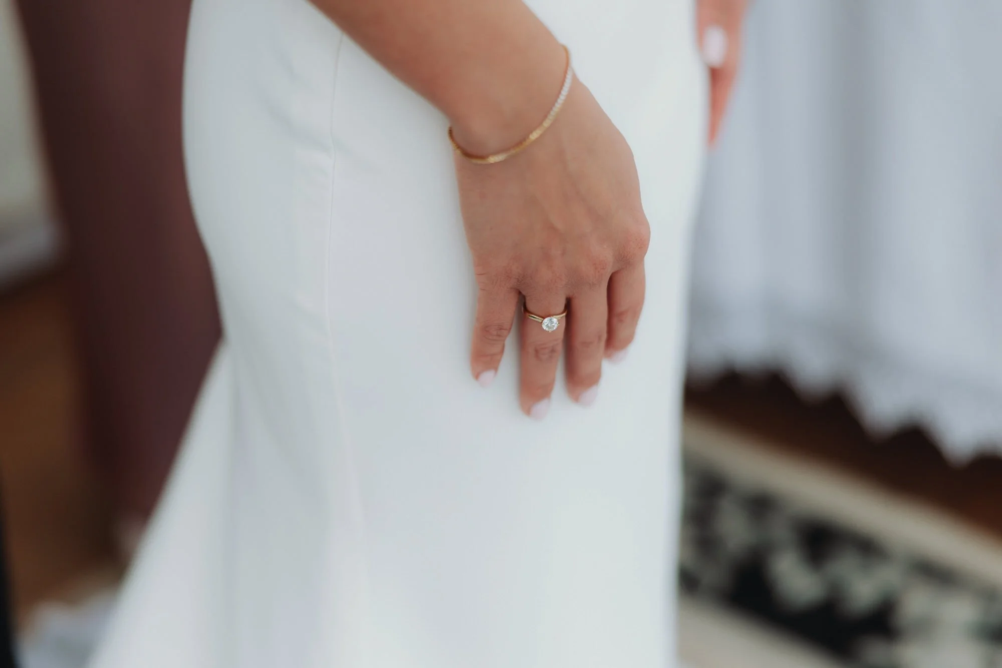 Caterina’s ring and bracelet against her wedding dress