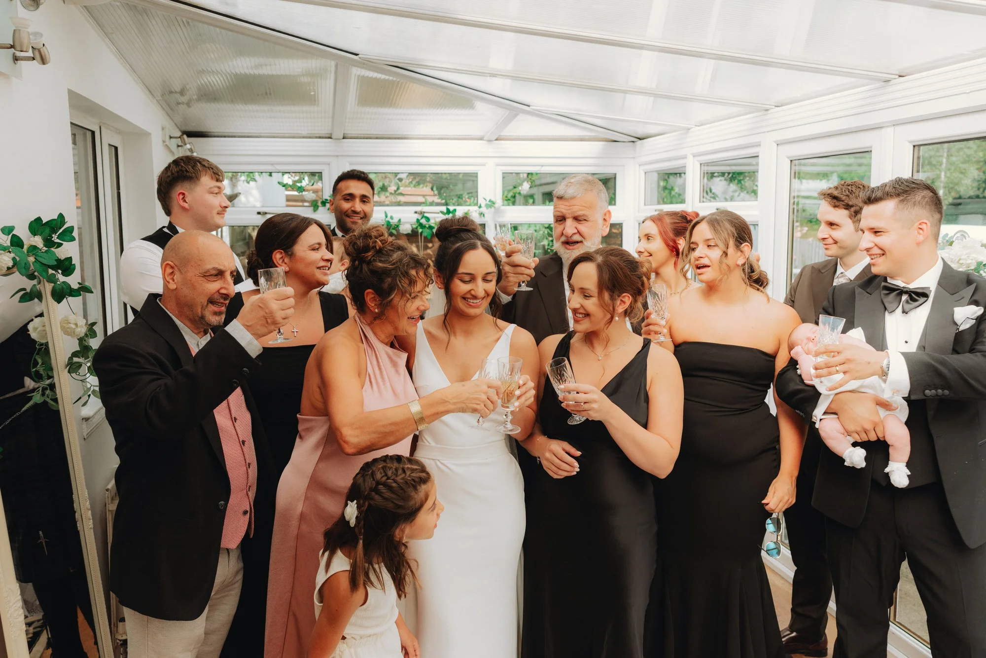 Caterina raising a glass with family and bridesmaids