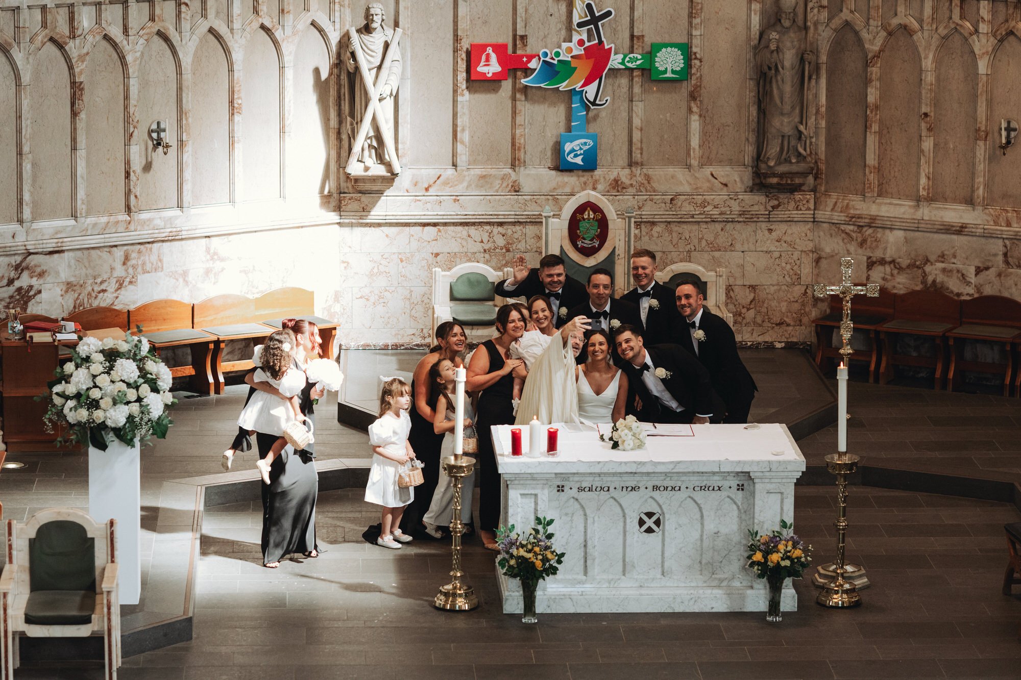 The newlyweds and witnesses posing beside the altar