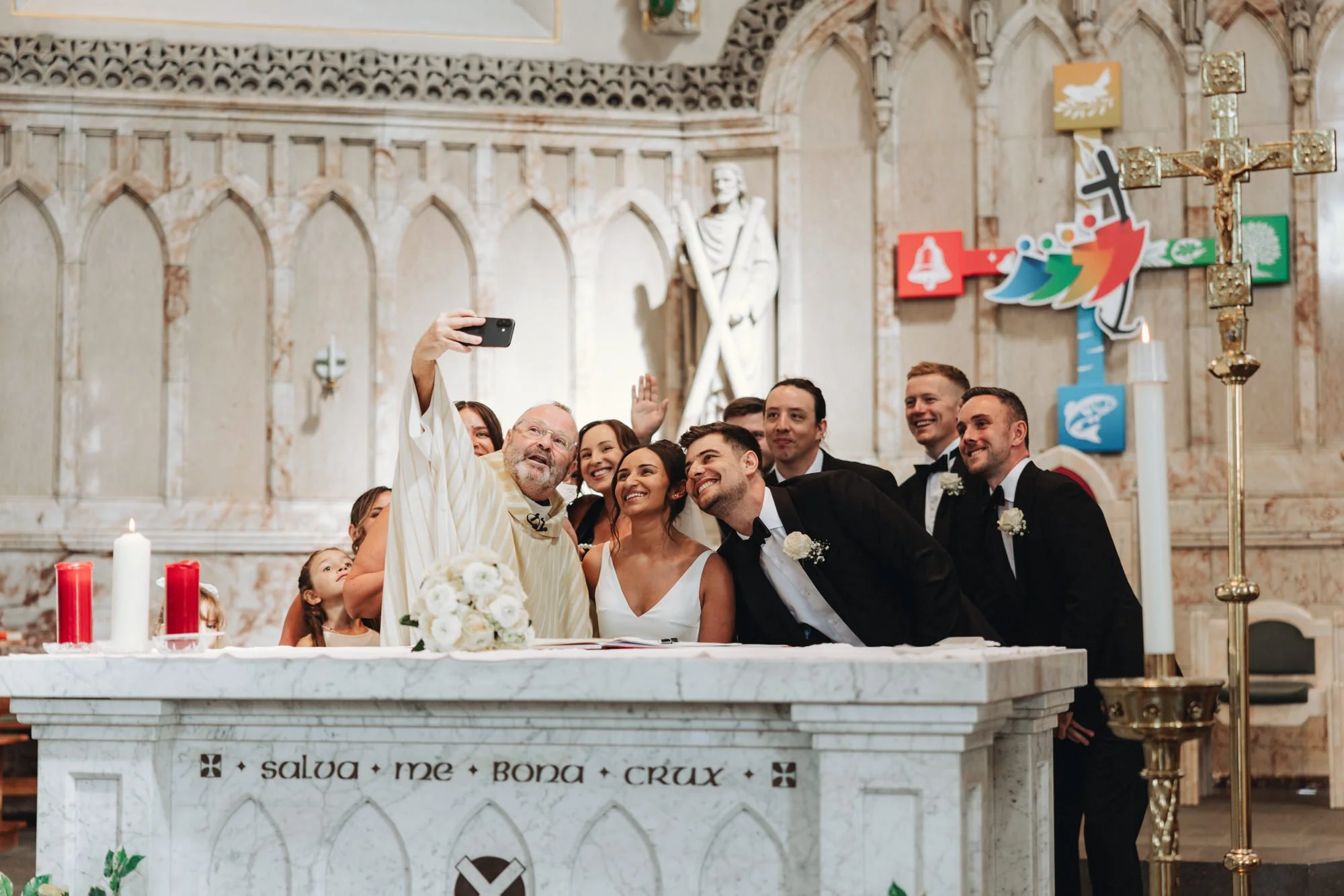 The priest taking a selfie with Caterina and Jonathan after the signing
