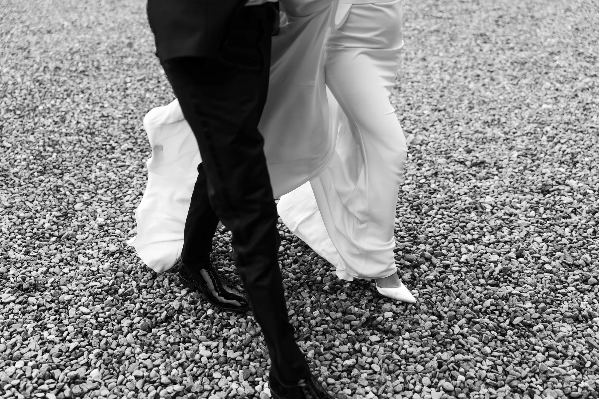Close-up of the couple’s wedding outfits on the gravel drive