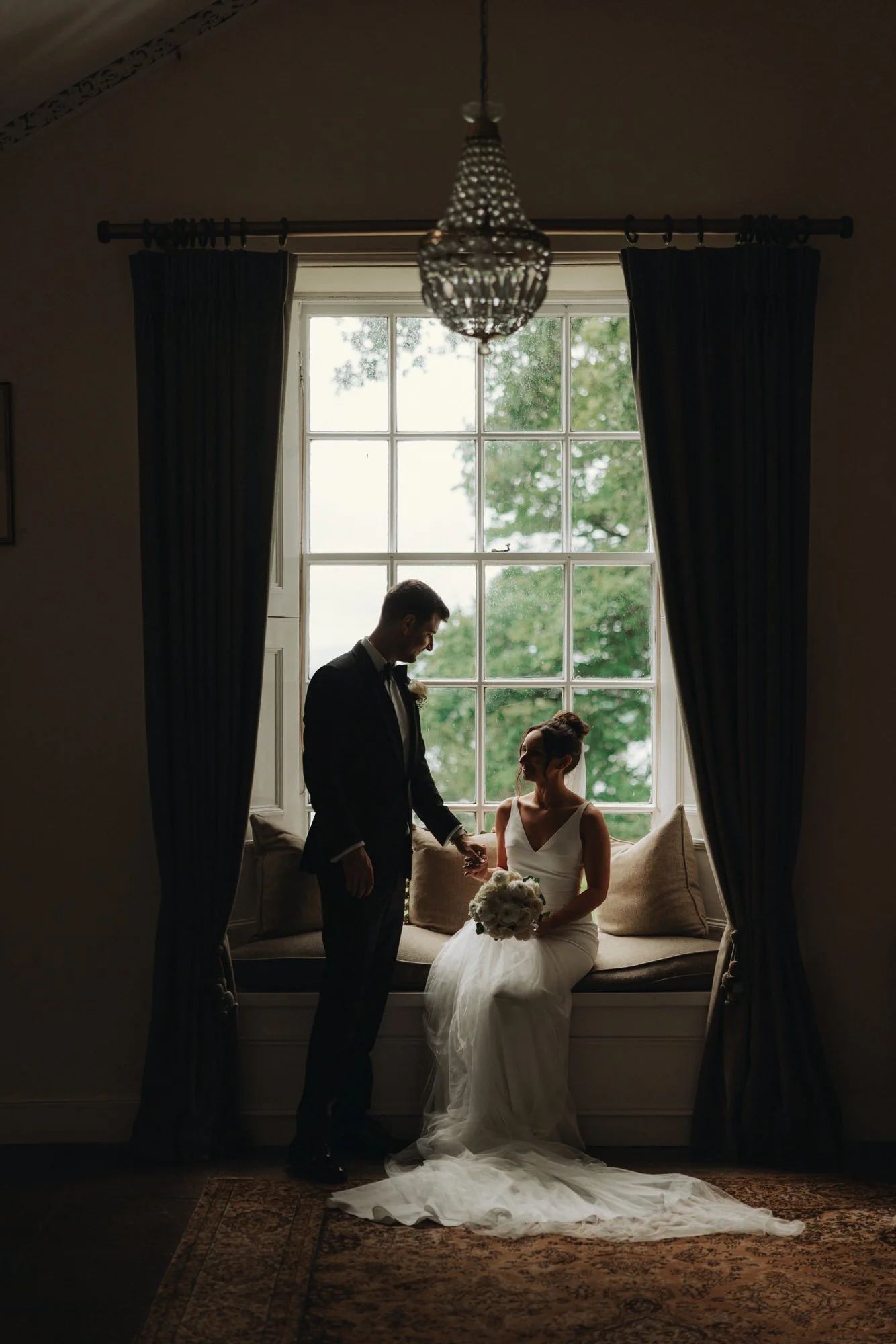 The couple silhouetted beside the drawing-room window