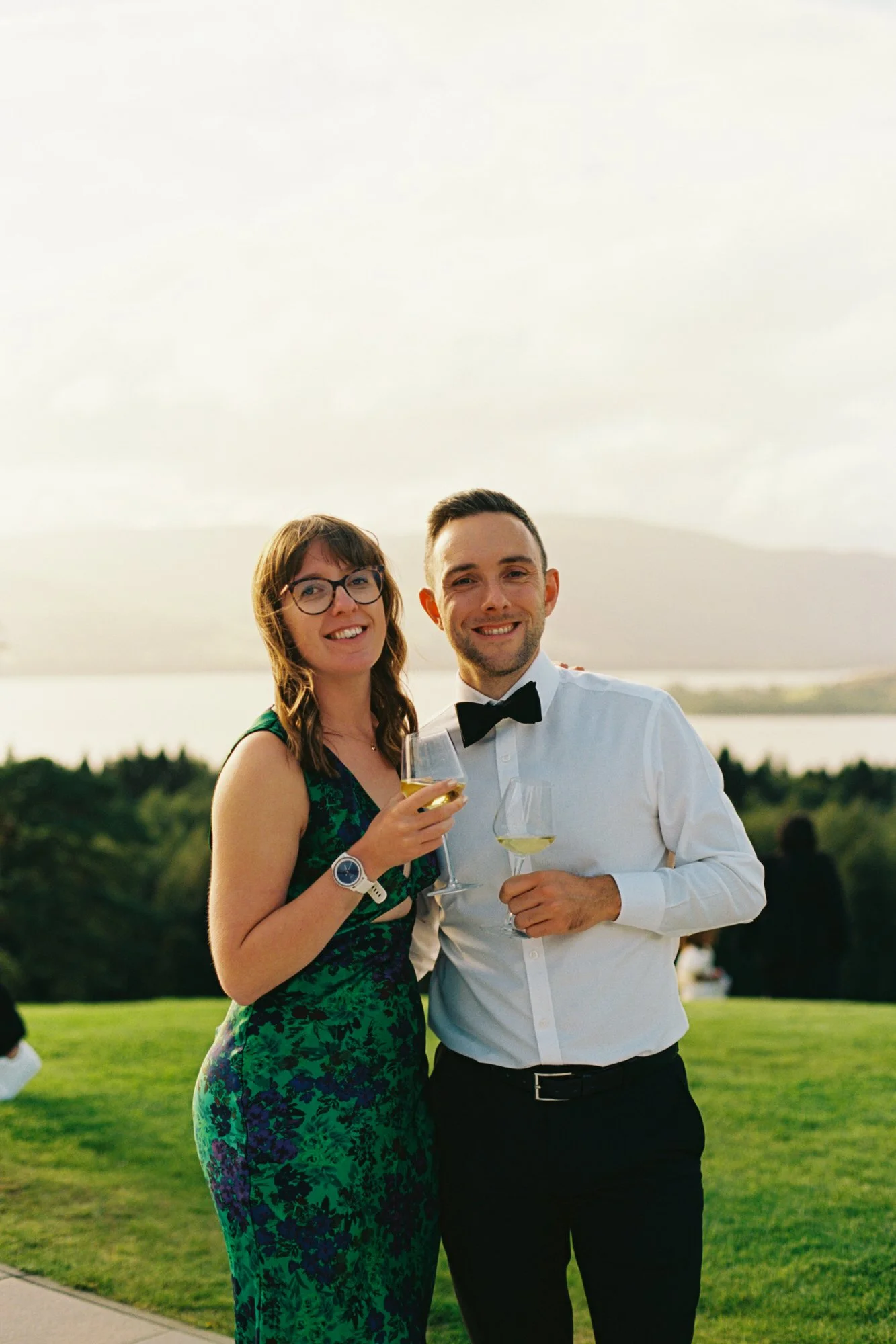 Two wedding guests posing with Loch Lomond in the background