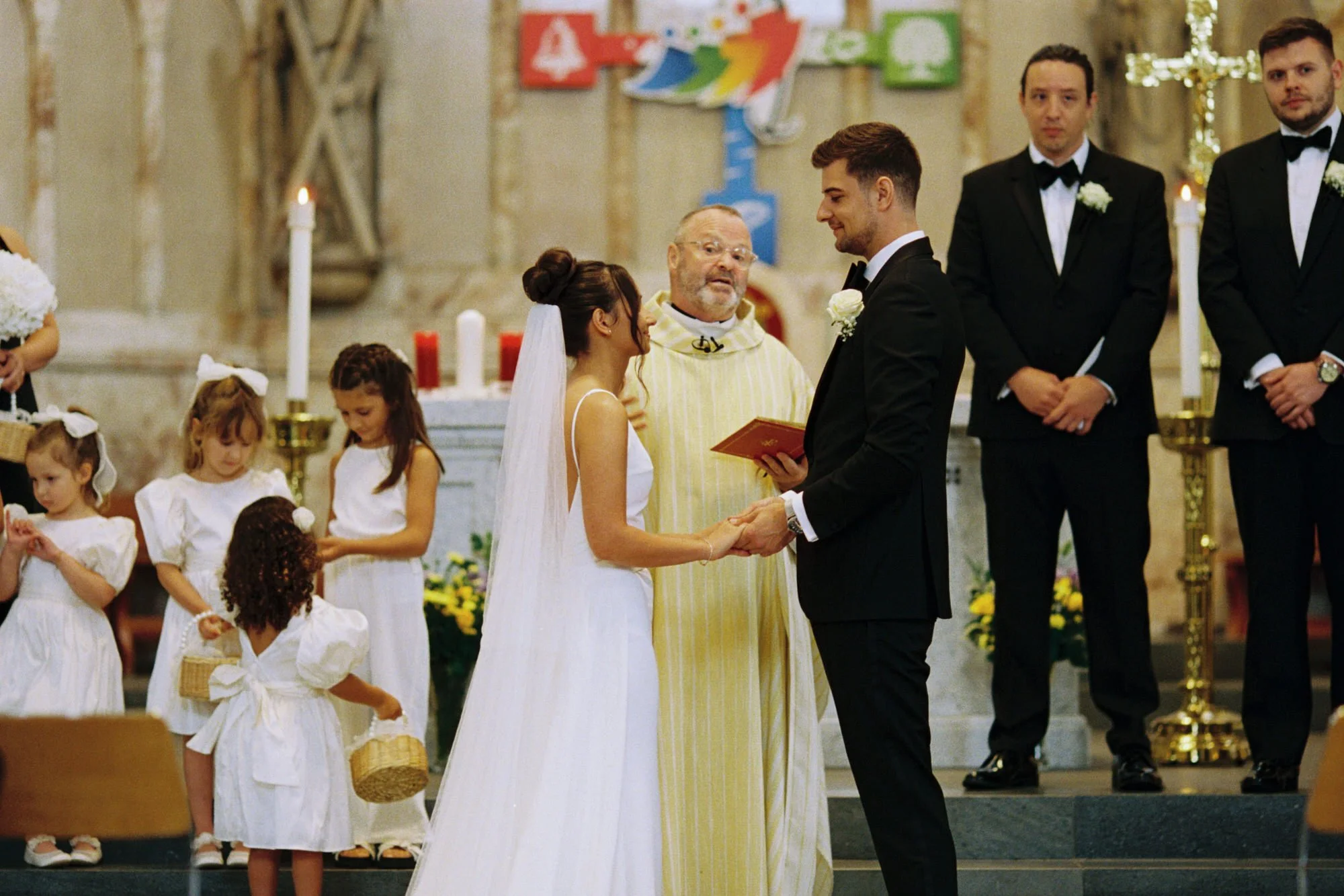 The priest speaking to Caterina and Jonathan at the altar