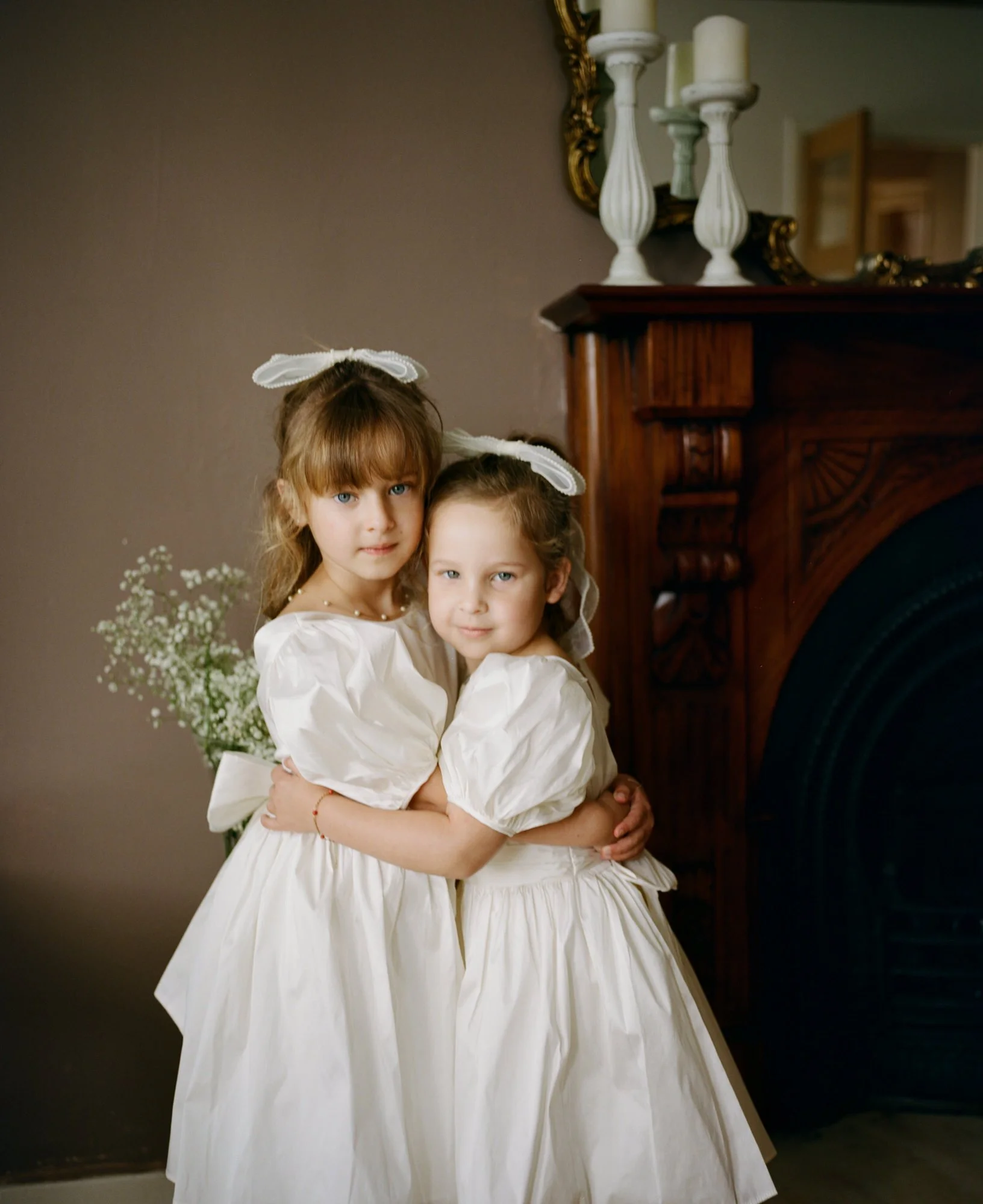 Two flower girls standing together inside the castle