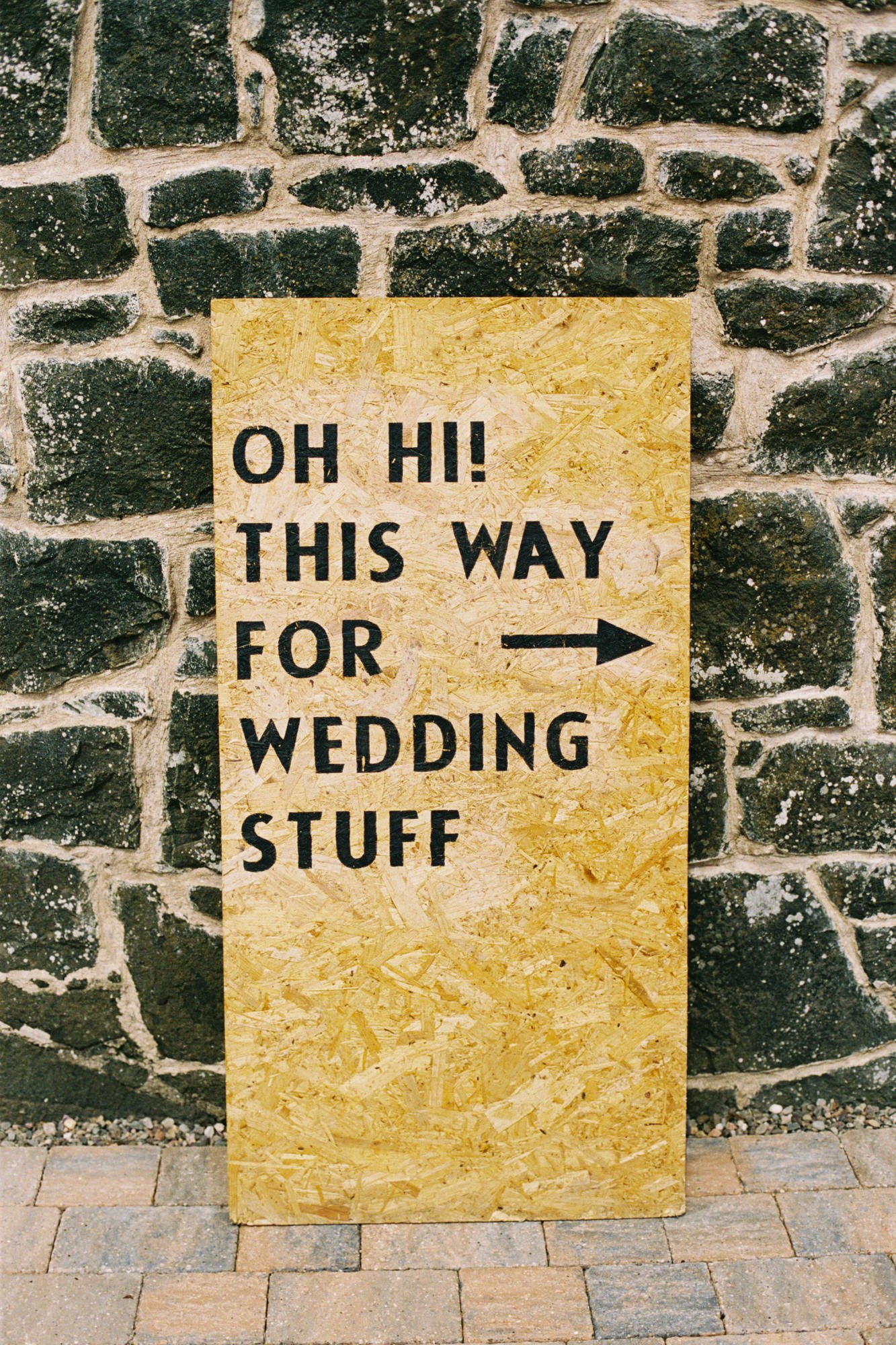 Wedding direction sign against a stone wall at Pratis Barns