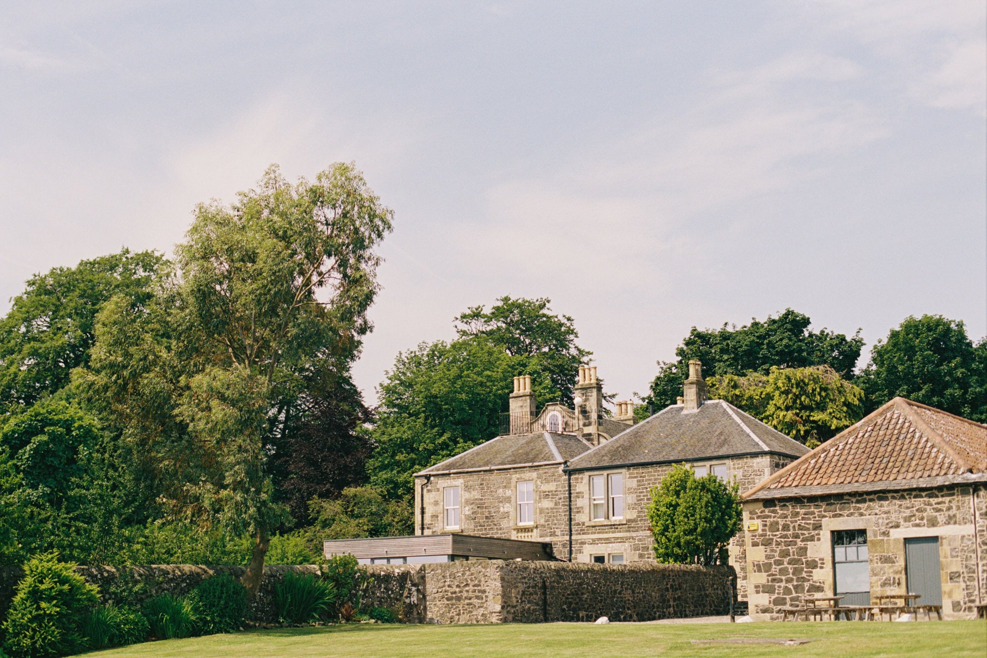Pratis House and stone barns surrounded by trees in Fife